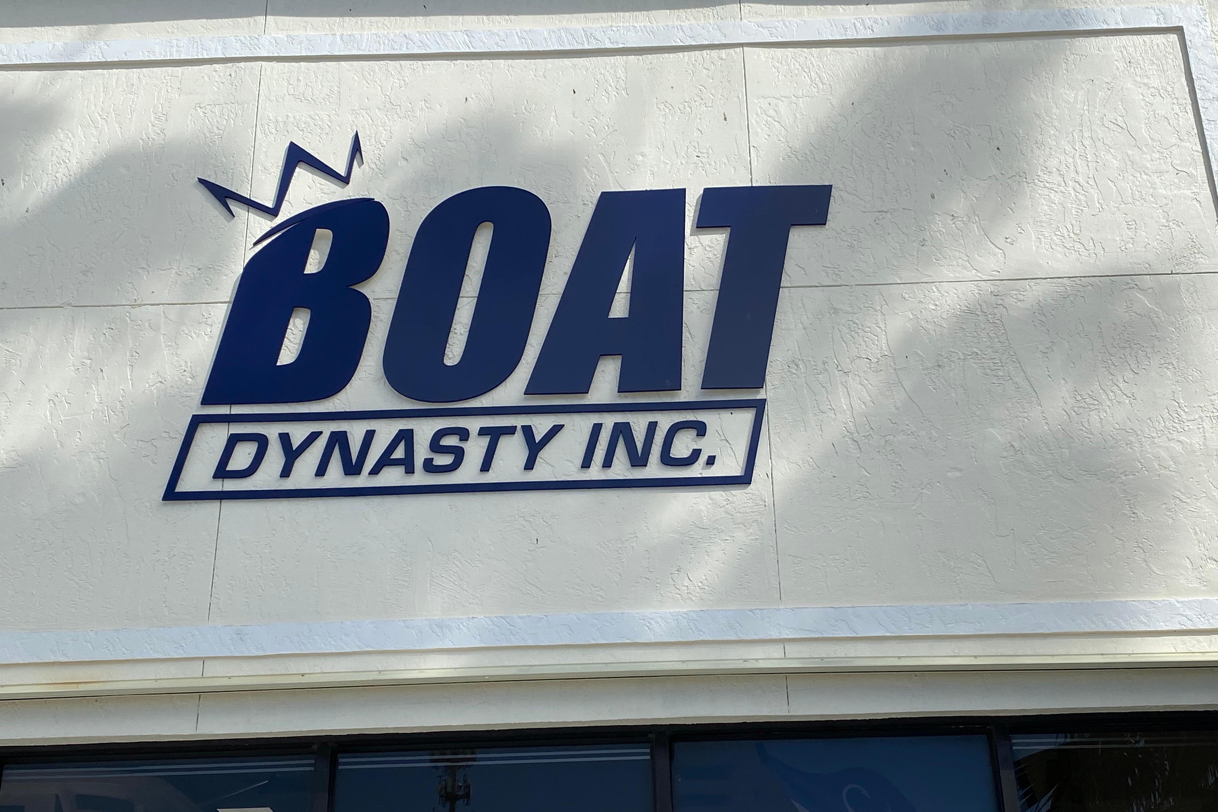 Boat Dynasty Inc. sign on textured wall, related to World Cat 255 DC 2022.