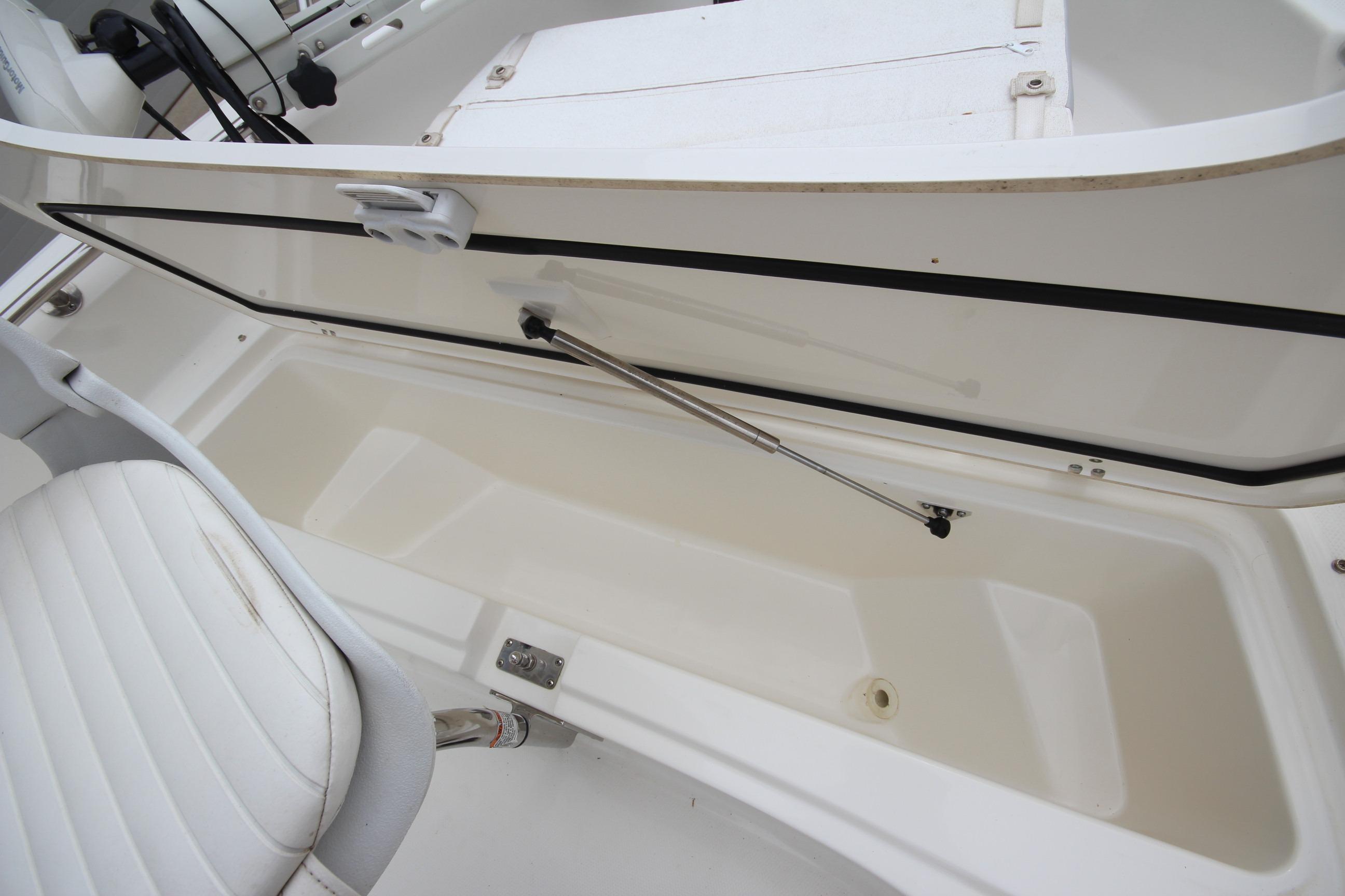 Open storage compartment on a 2014 Boston Whaler 210 Dauntless boat, showcasing interior space.