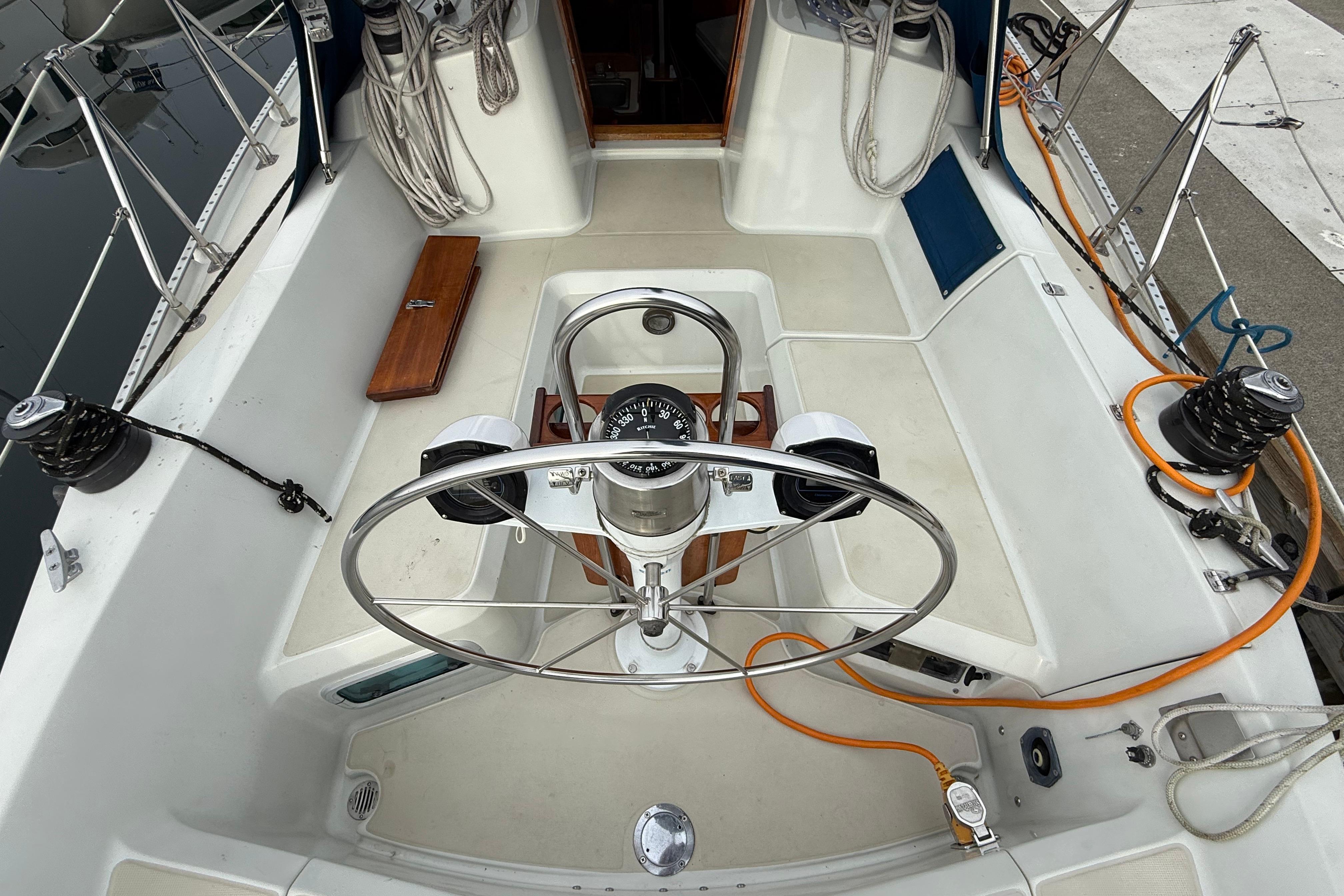 Cockpit of 1988 Ericson 32-200 sailboat with steering wheel and navigation instruments.