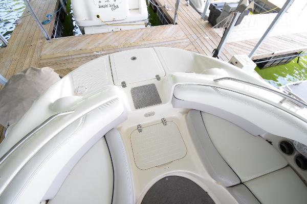 The image shows the cockpit of a 2010 Bryant 255 boat with white upholstery.