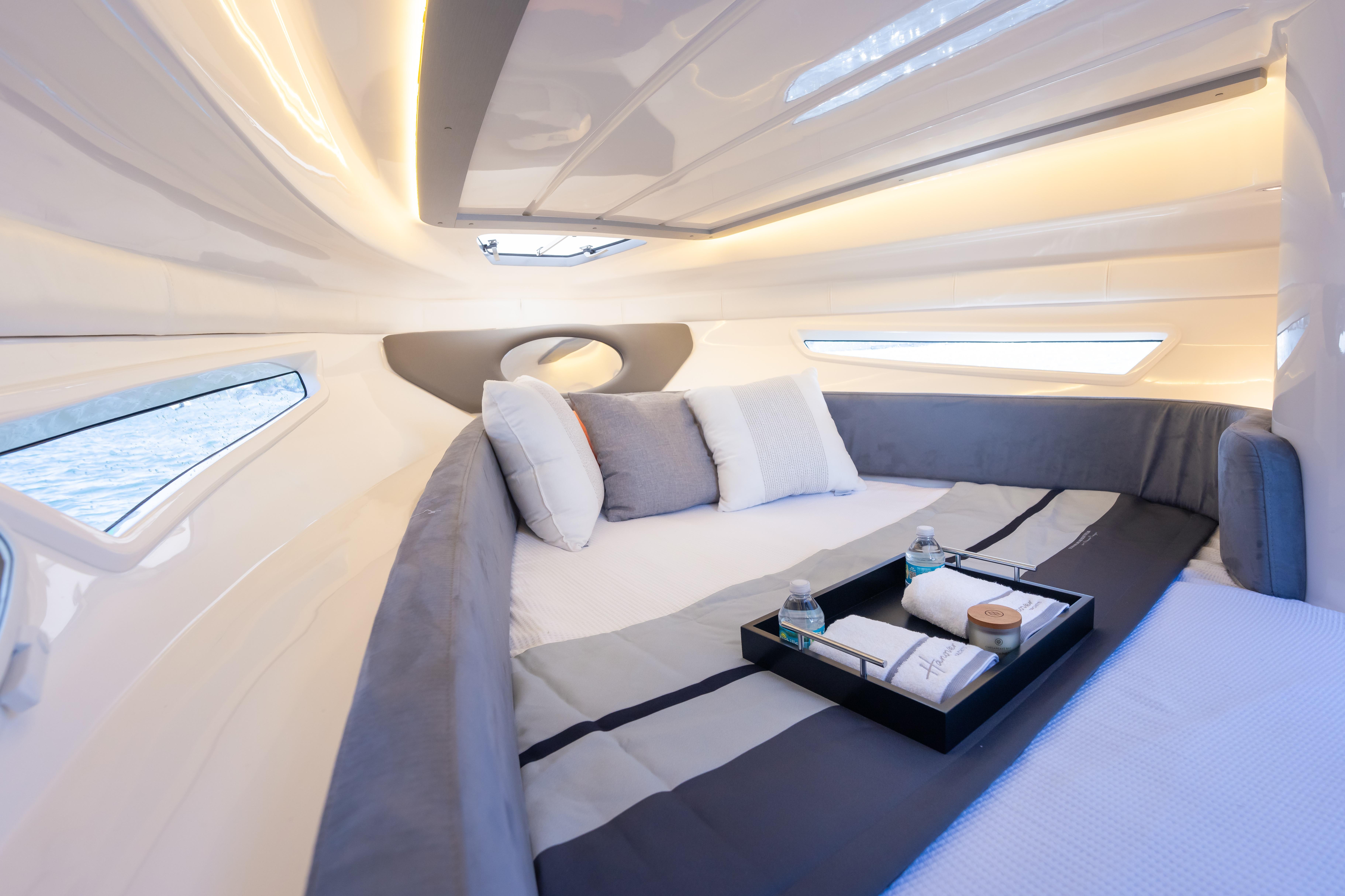 Luxurious interior of 2026 Hanover 305 yacht with cozy bedding and elegant lighting.