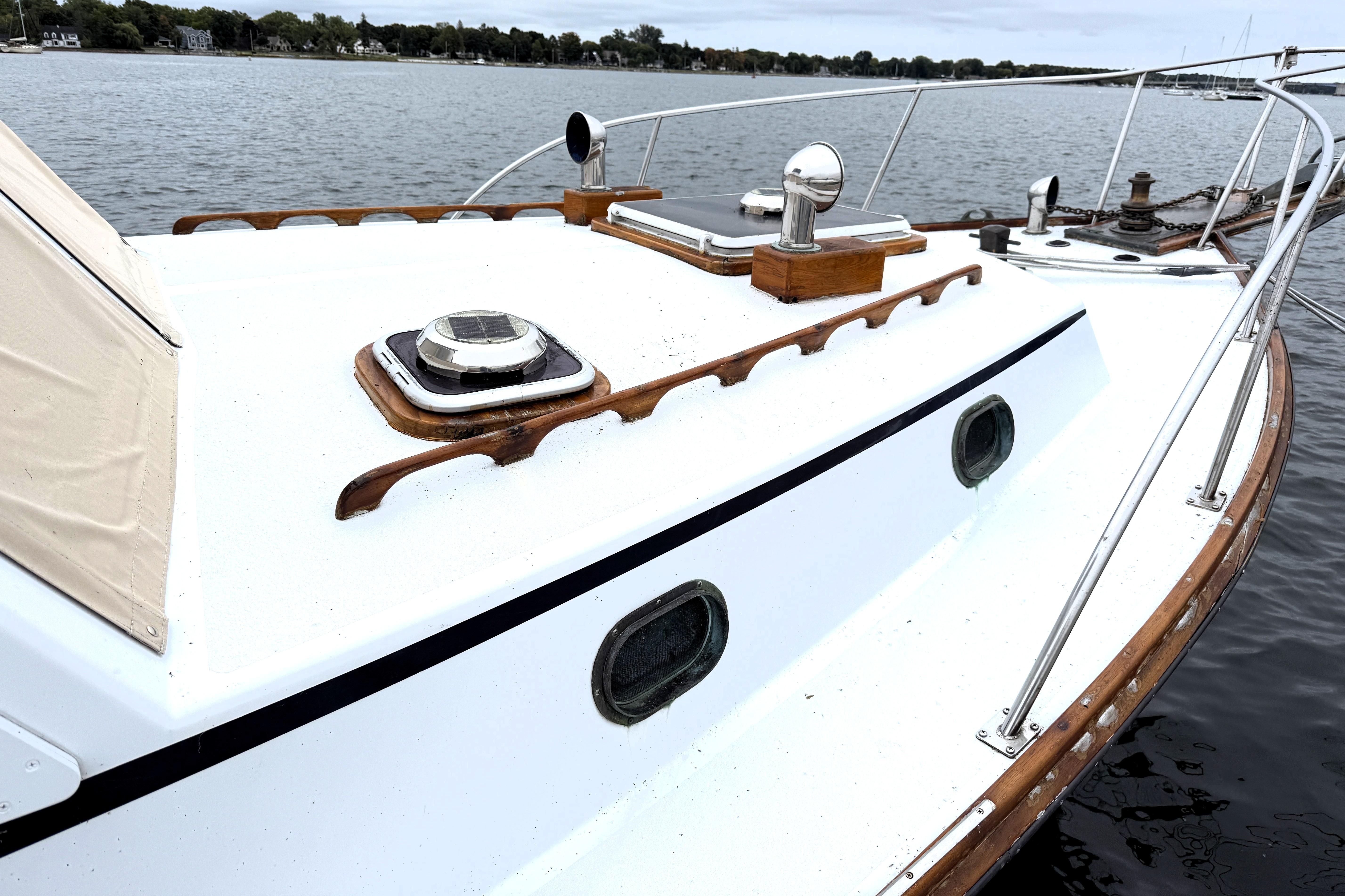 1983 Wilbur 34 Fly Bridge Cruiser on calm water, showcasing deck and portholes.