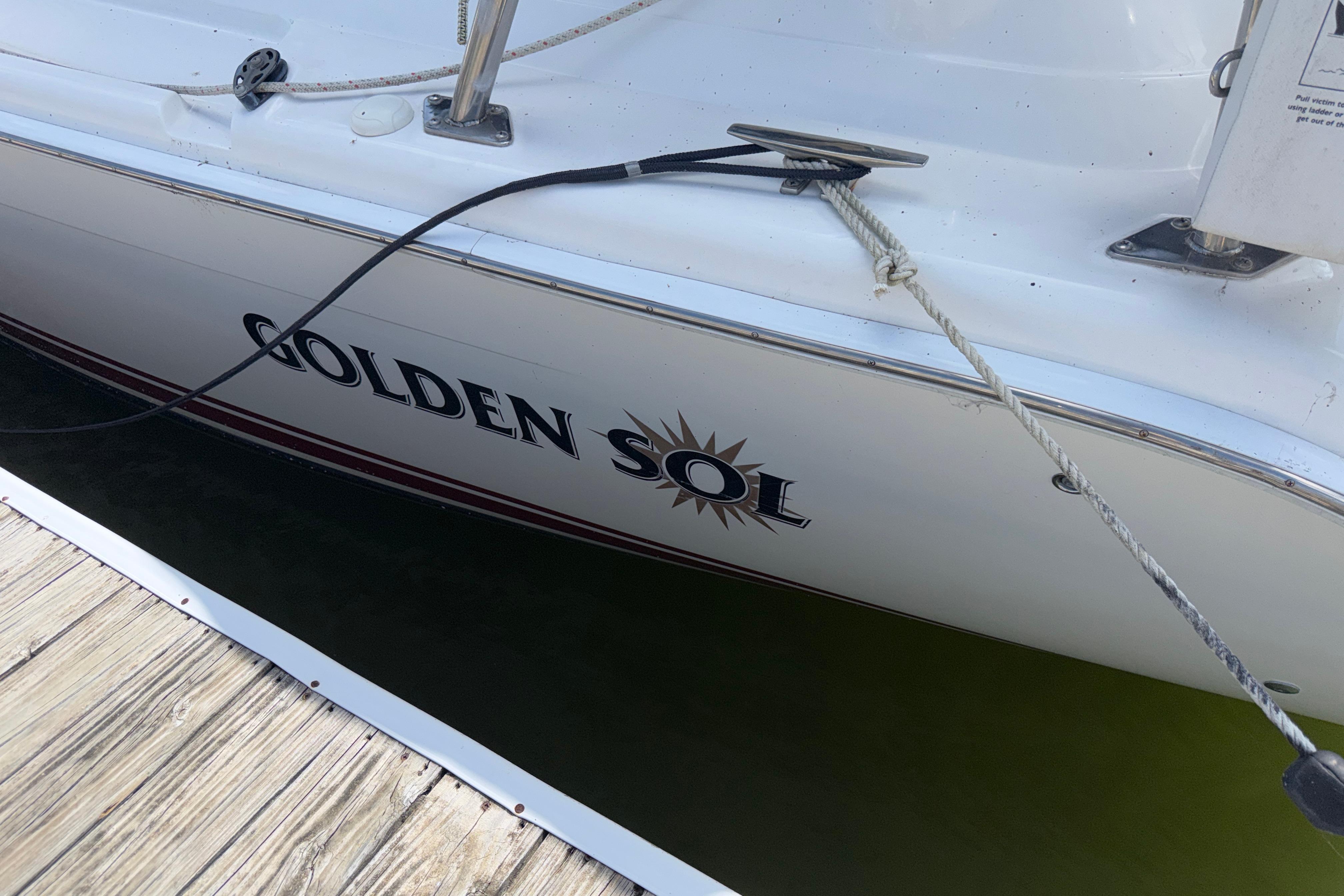 Hunter 38 sailboat named "Golden Sol" docked, 2005 model, with visible mooring lines.