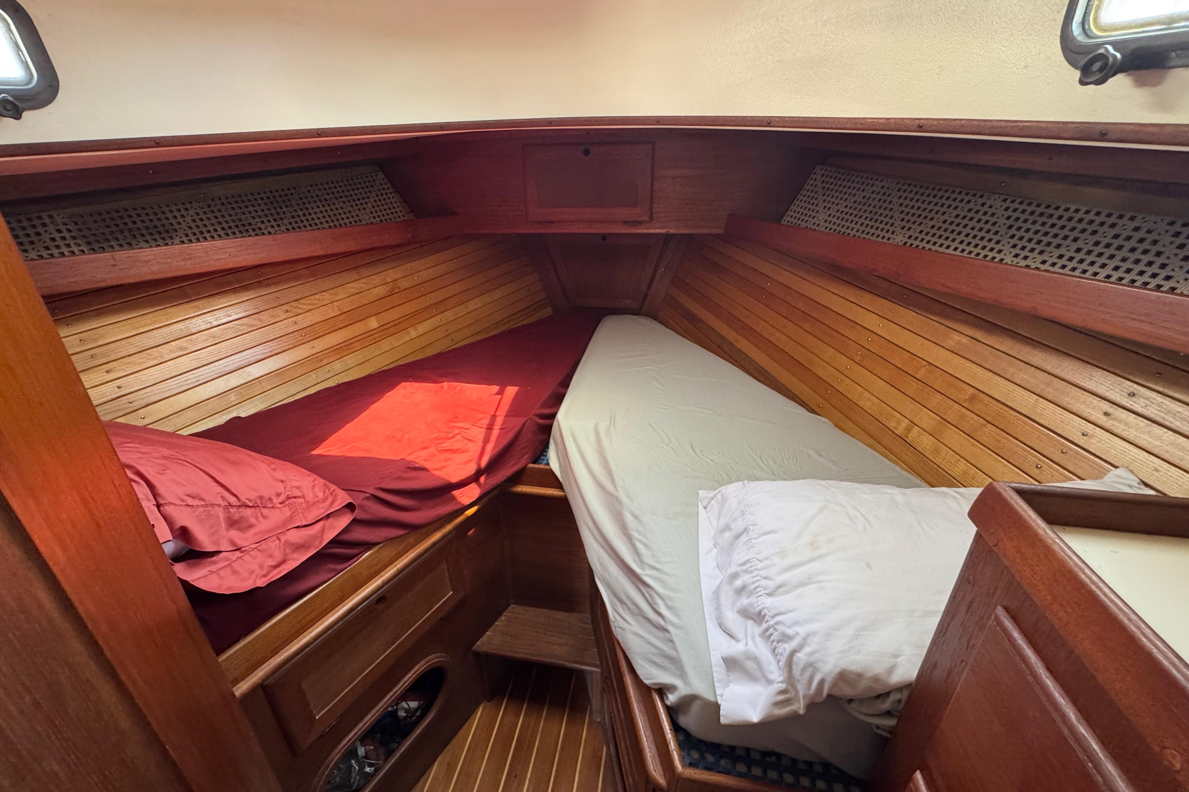 Cozy cabin interior of 1989 Cape Dory 30 Motorsailer with wooden paneling and twin beds.