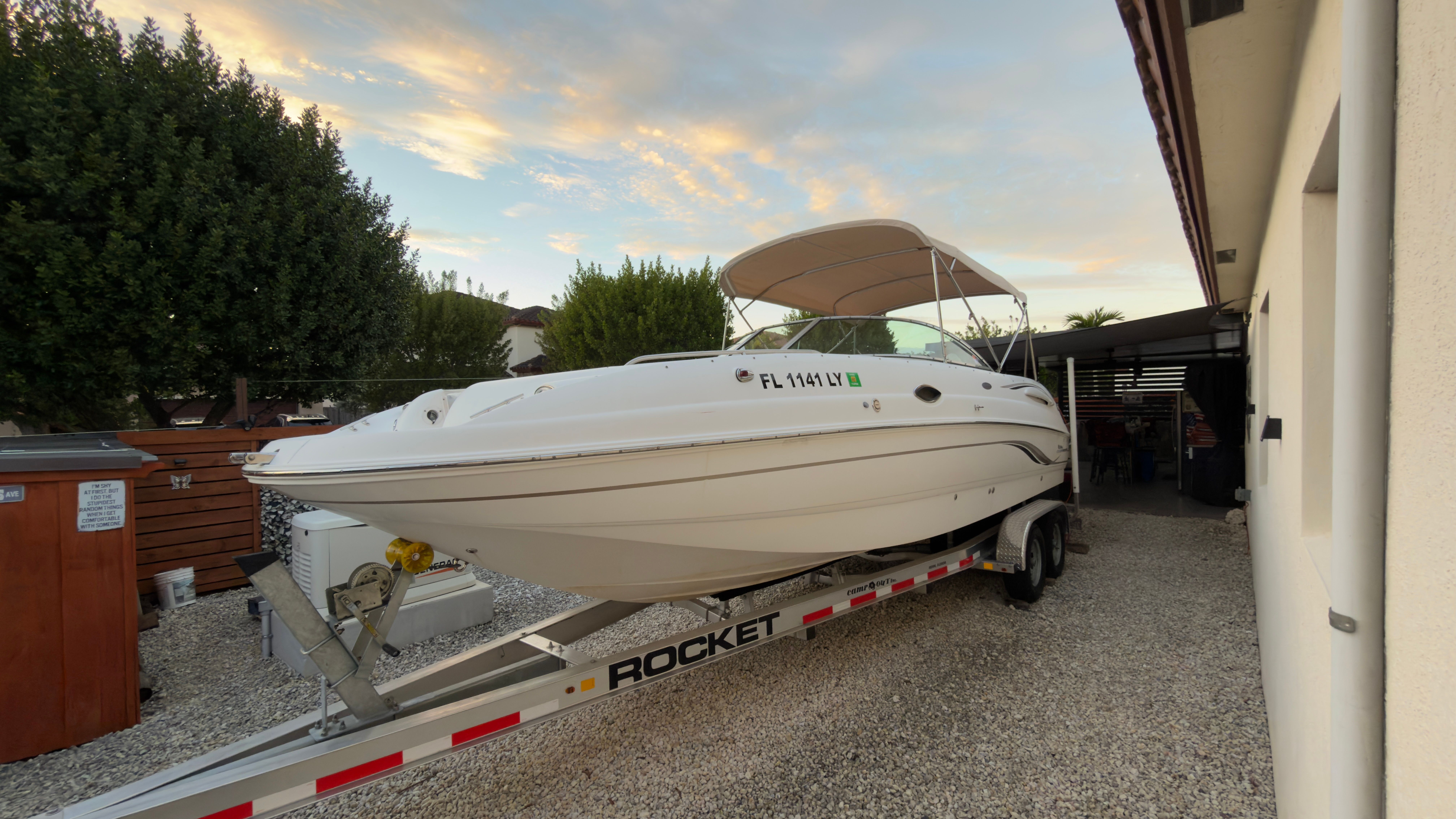 2003 Chaparral 263 Sunesta Deckboat on trailer in yard.