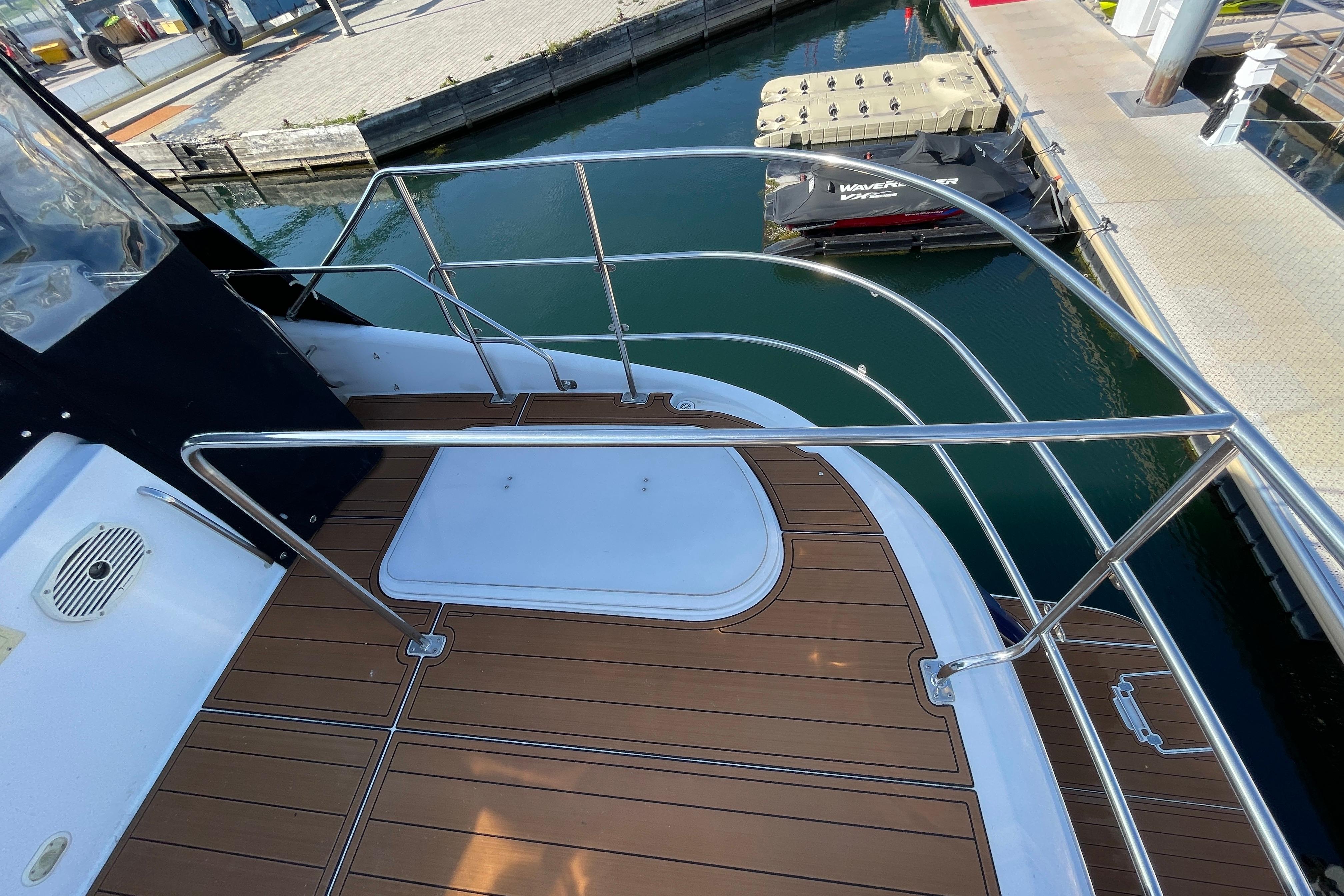 2002 Carver 570 Voyager Pilothouse yacht deck with stainless steel railings at marina.