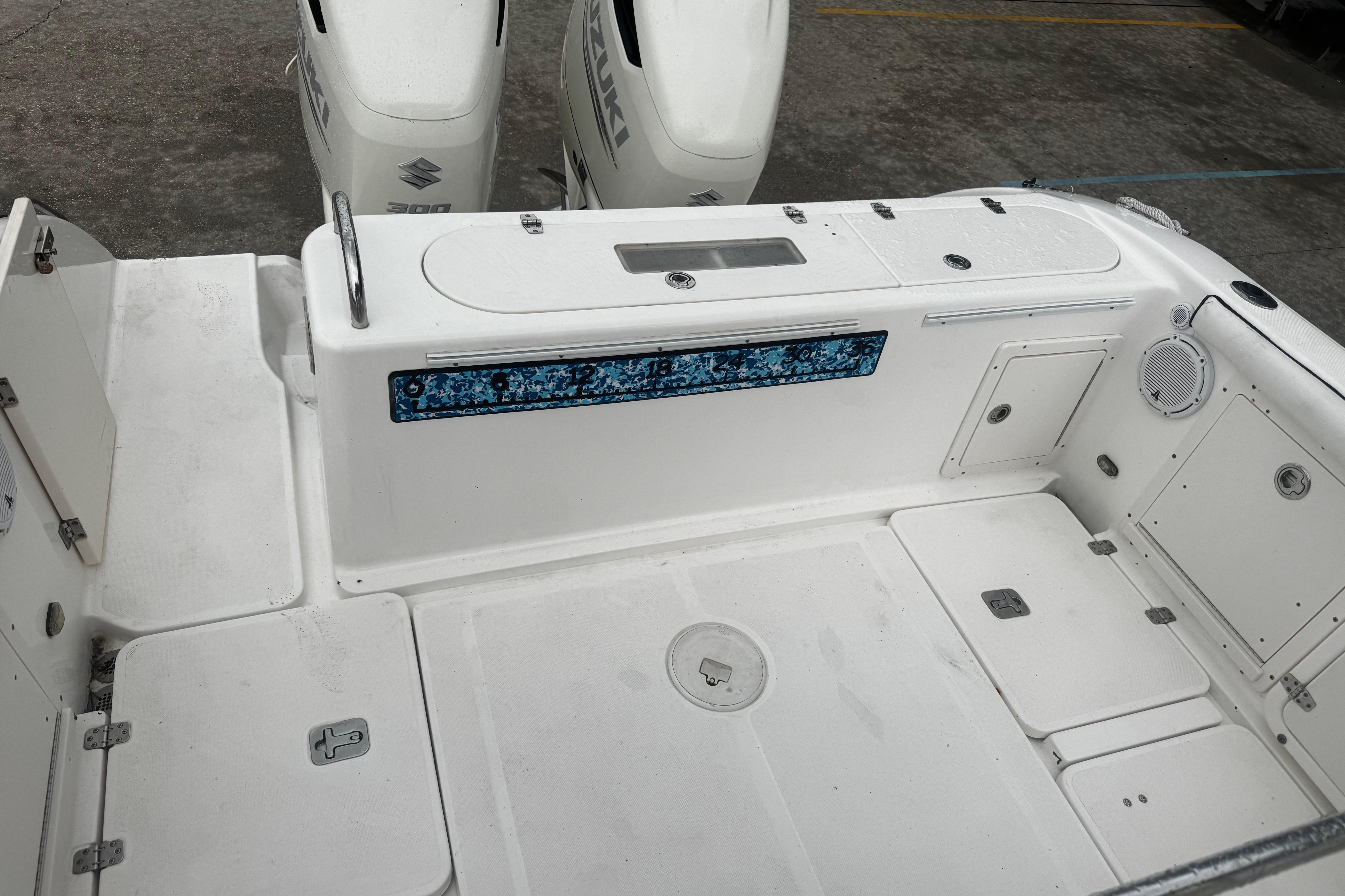 2004 Century 2900 Center Console boat deck with Suzuki engines, featuring storage compartments.