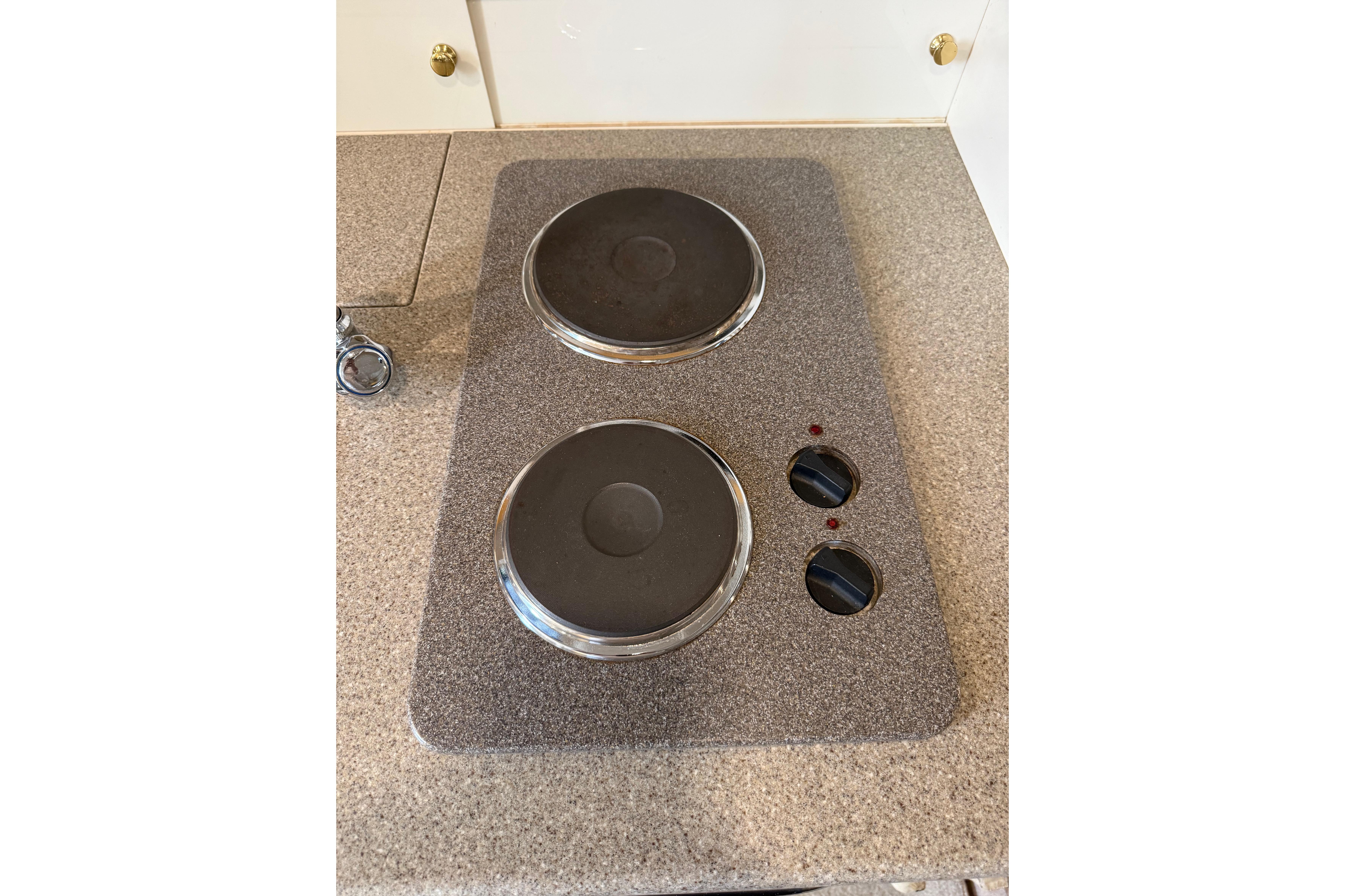 Electric stove on 1999 Formula 34 Performance Cruiser, featuring dual burners and control knobs.