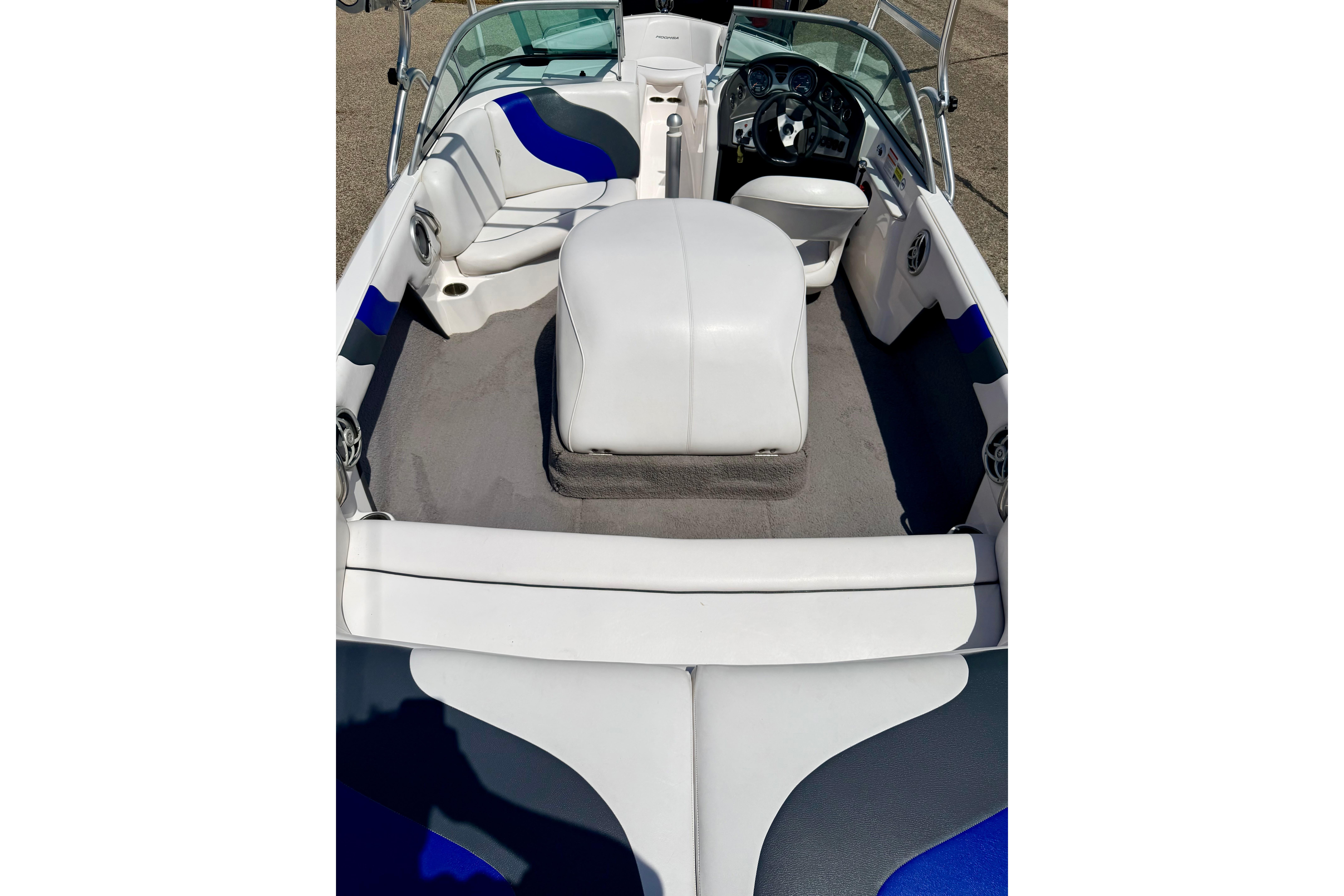 2008 Moomba Outback V boat interior with white and blue seating, steering wheel, and dashboard.