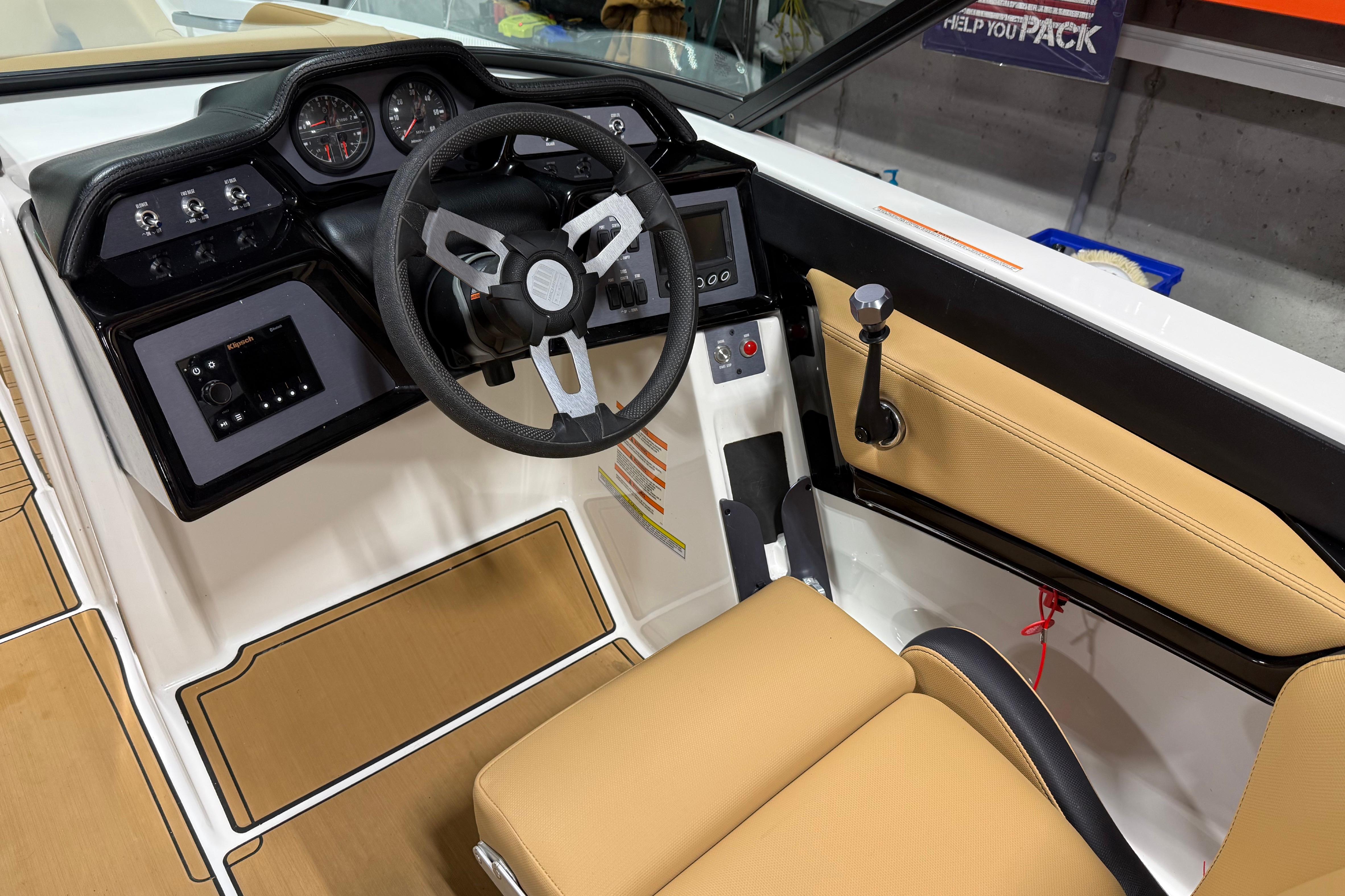 Interior of 2022 MasterCraft NXT24 boat, featuring steering wheel and control panel.