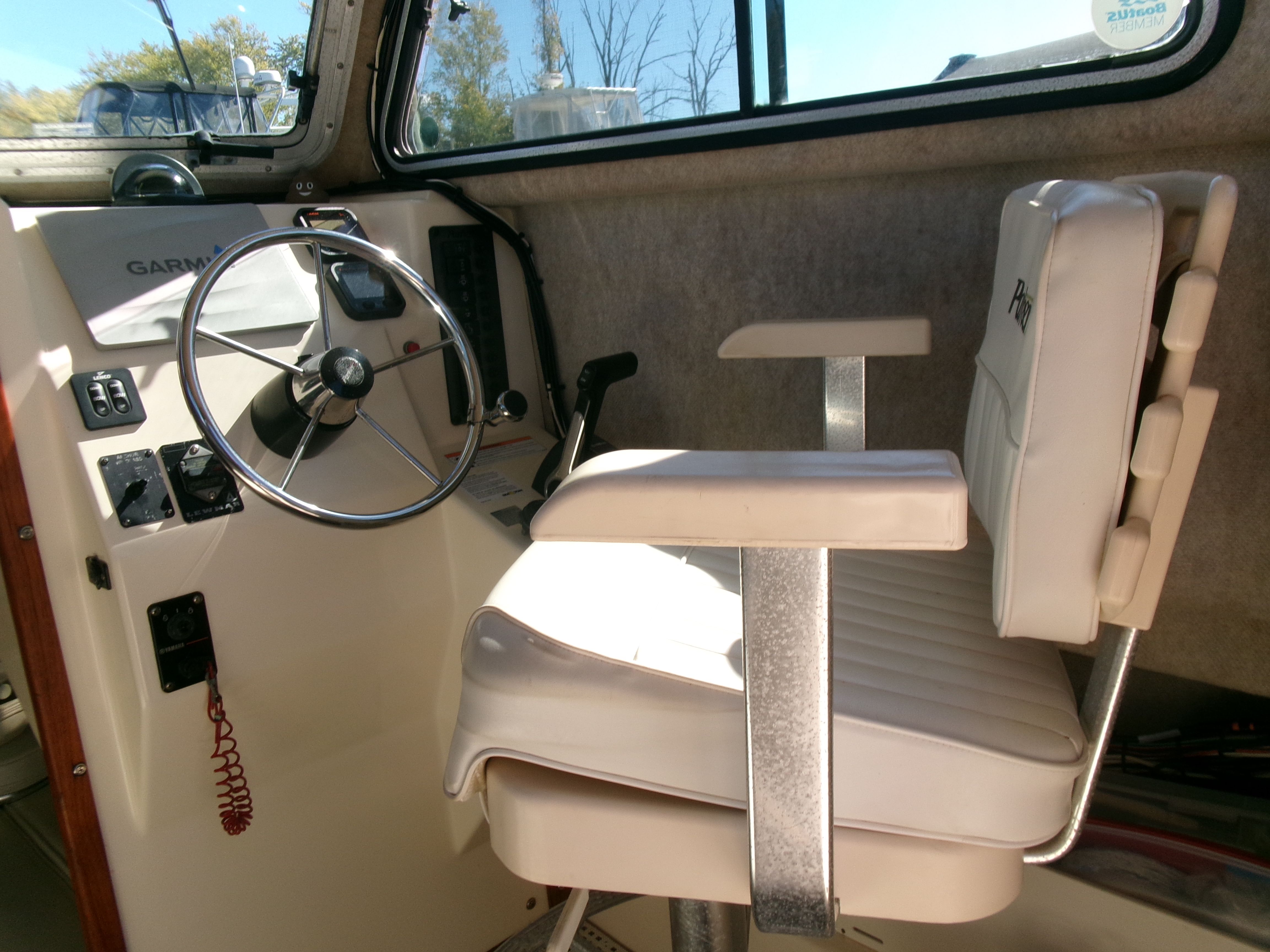 Interior view of a 2007 Parker 2520 XL Sport Cabin boat with steering wheel and seat.