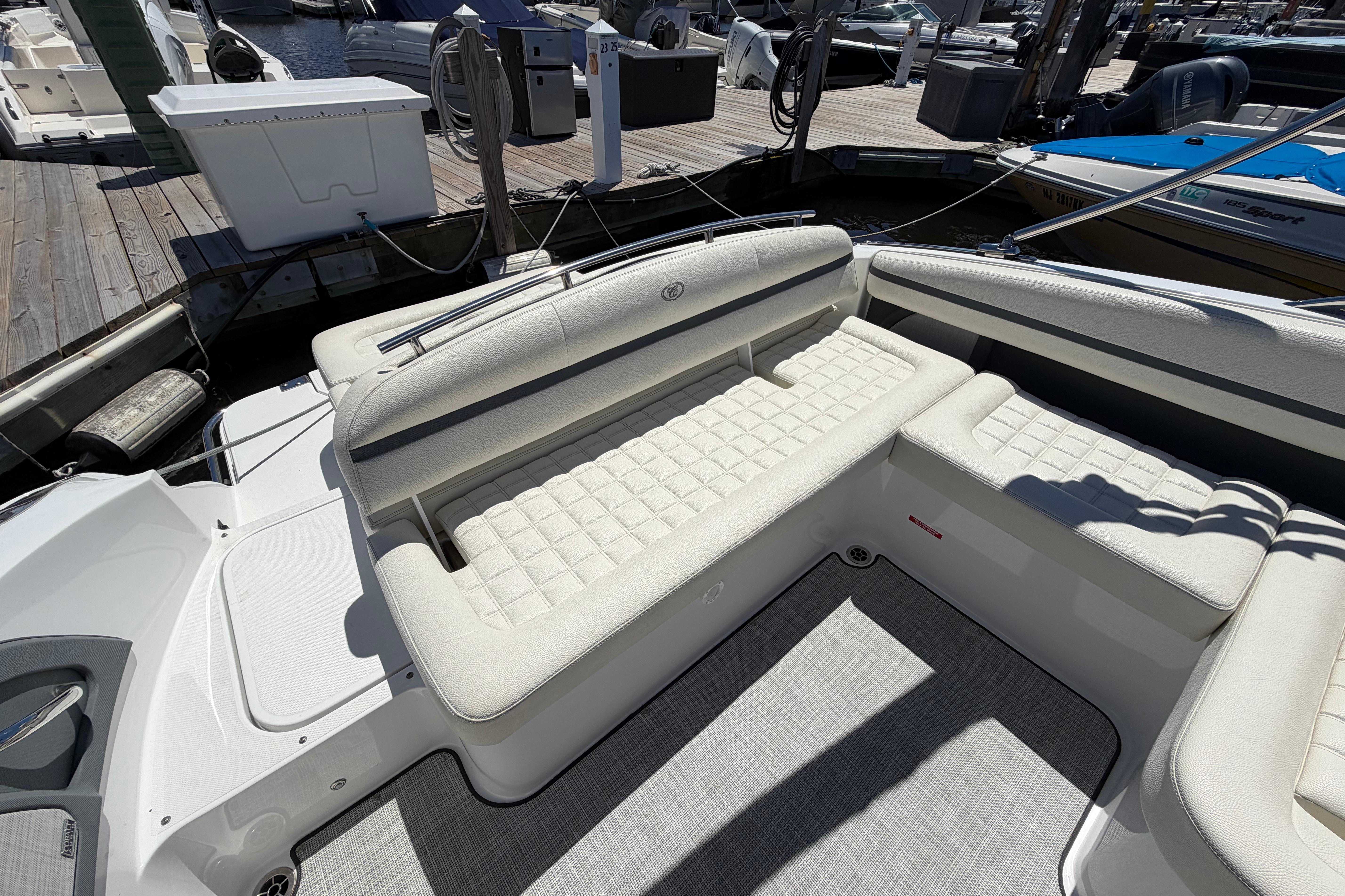 2020 Cobalt R3 boat interior with white cushioned seating at a marina.