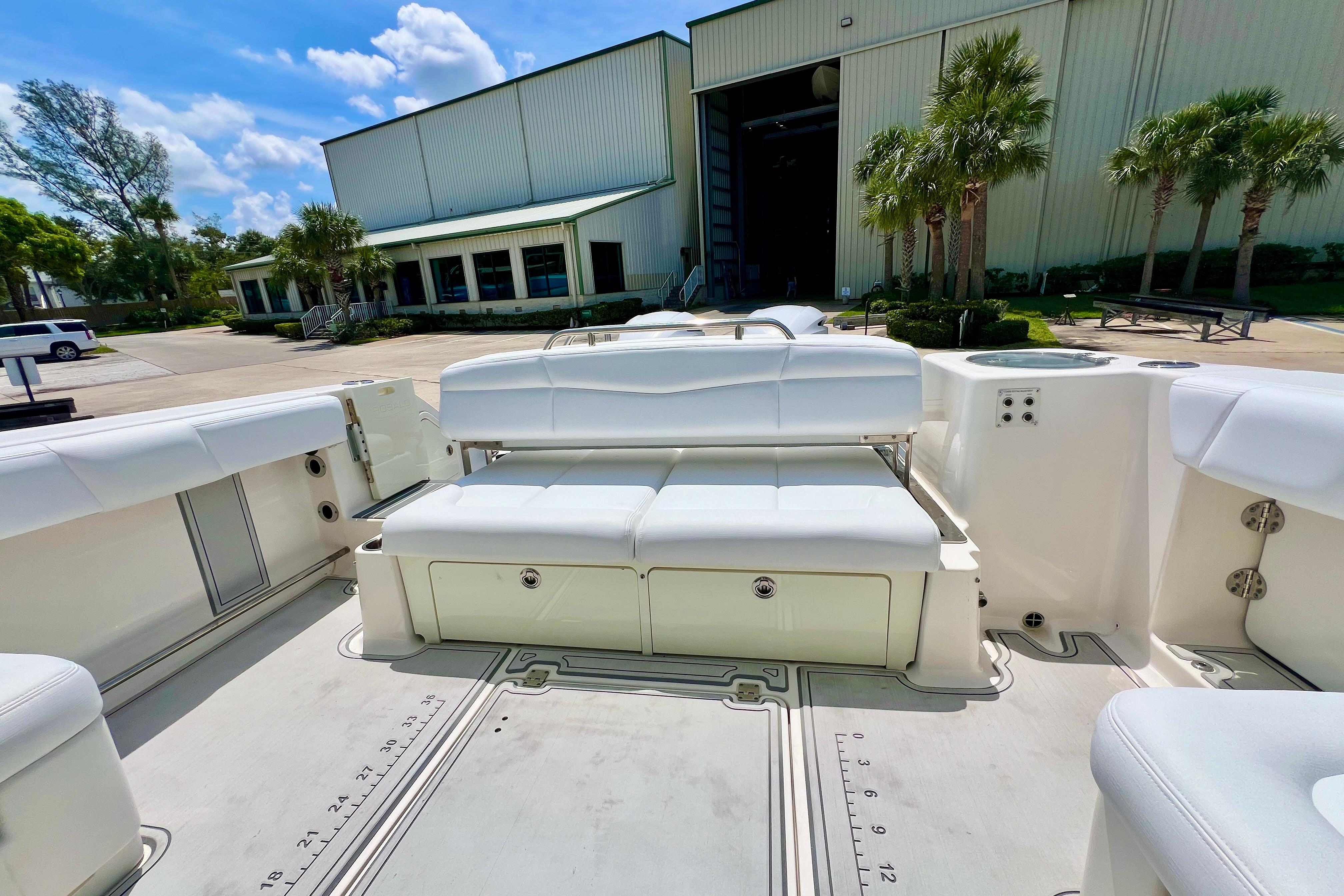 2019 Robalo R317 Dual Console boat with white seating, docked near a building.