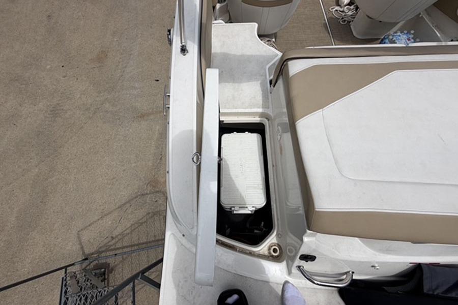 2018 Sea Ray SPX 190 boat interior with open storage compartment and beige seating.