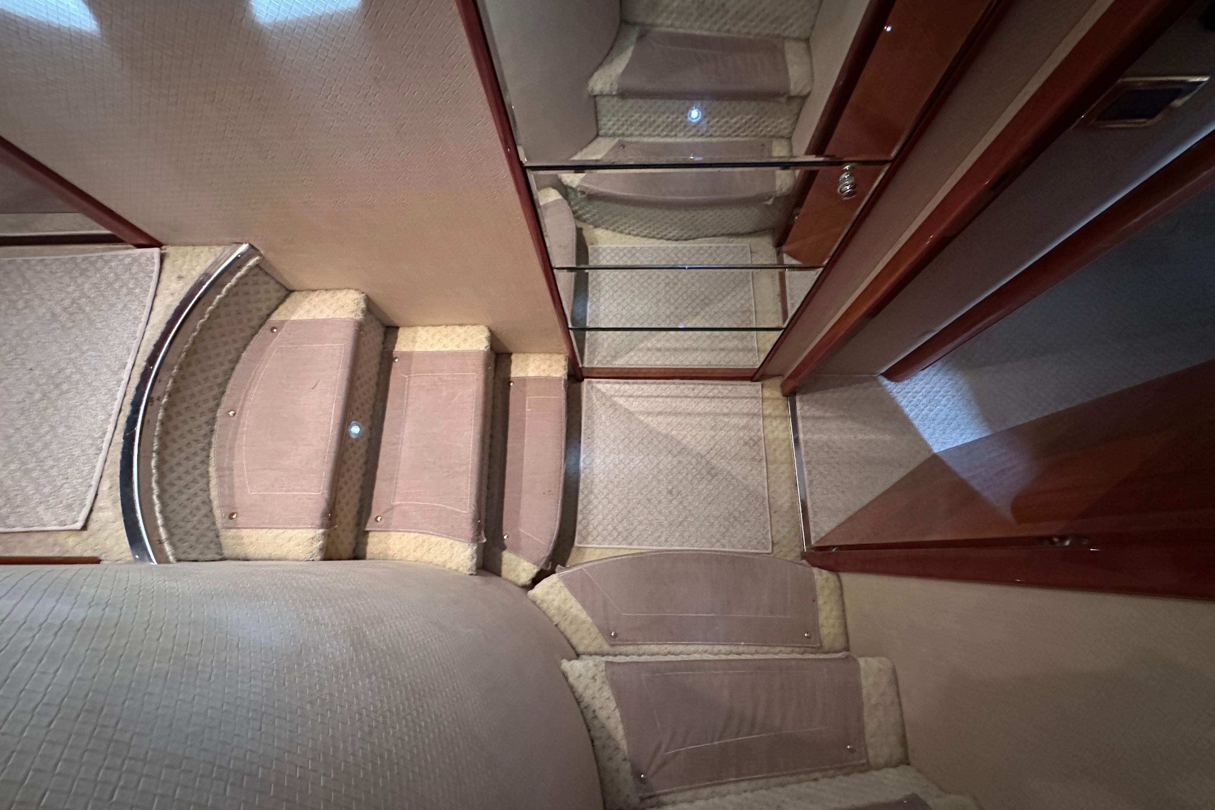 Interior stairs of a 2004 Azimut 55E yacht, featuring elegant wood and carpet design.