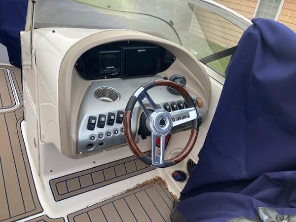 2006 Hurricane SunDeck 237 OB boat dashboard with steering wheel and control panel.
