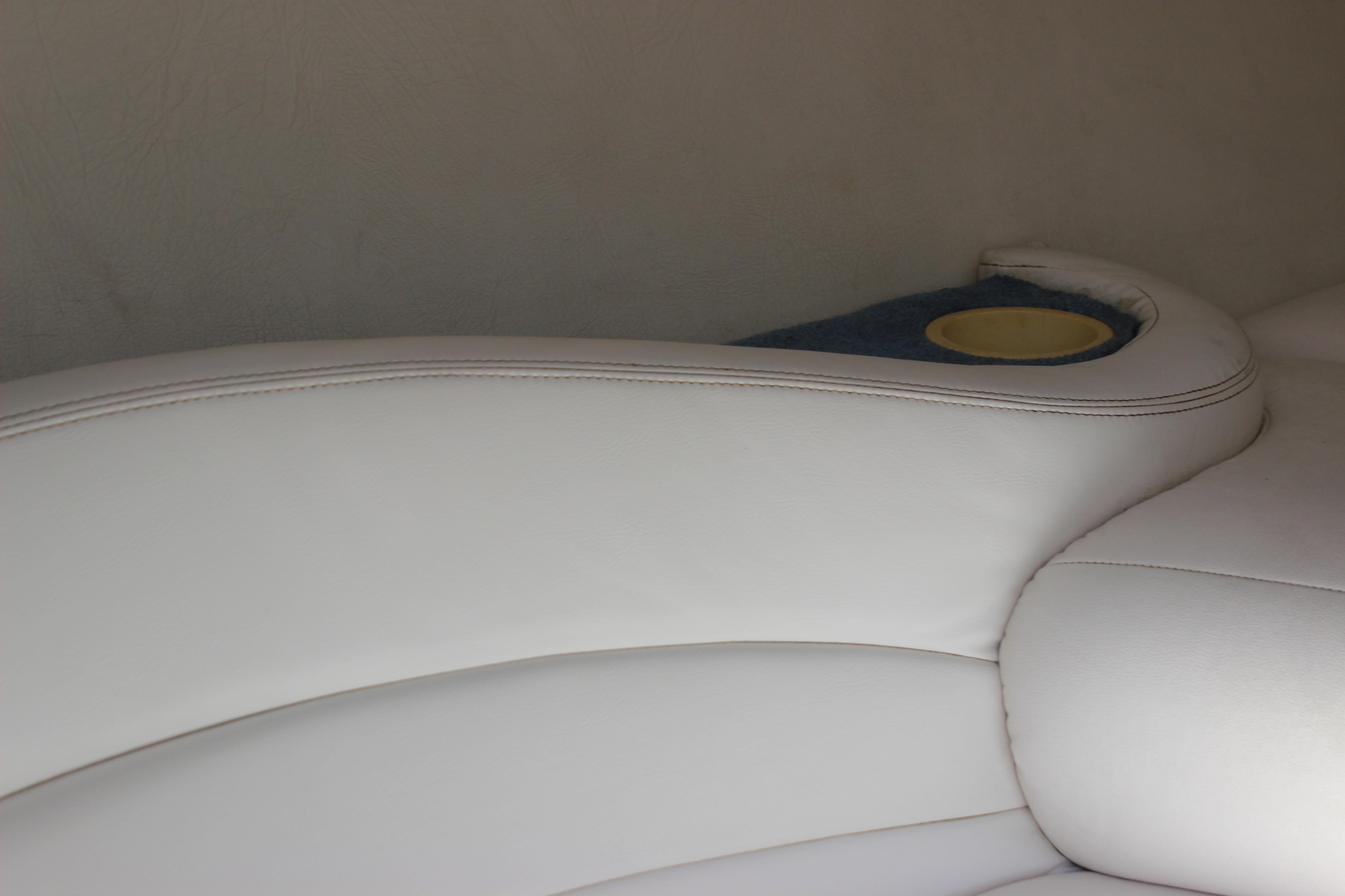 White leather seating with cup holder on a 1995 Baja 272 boat.