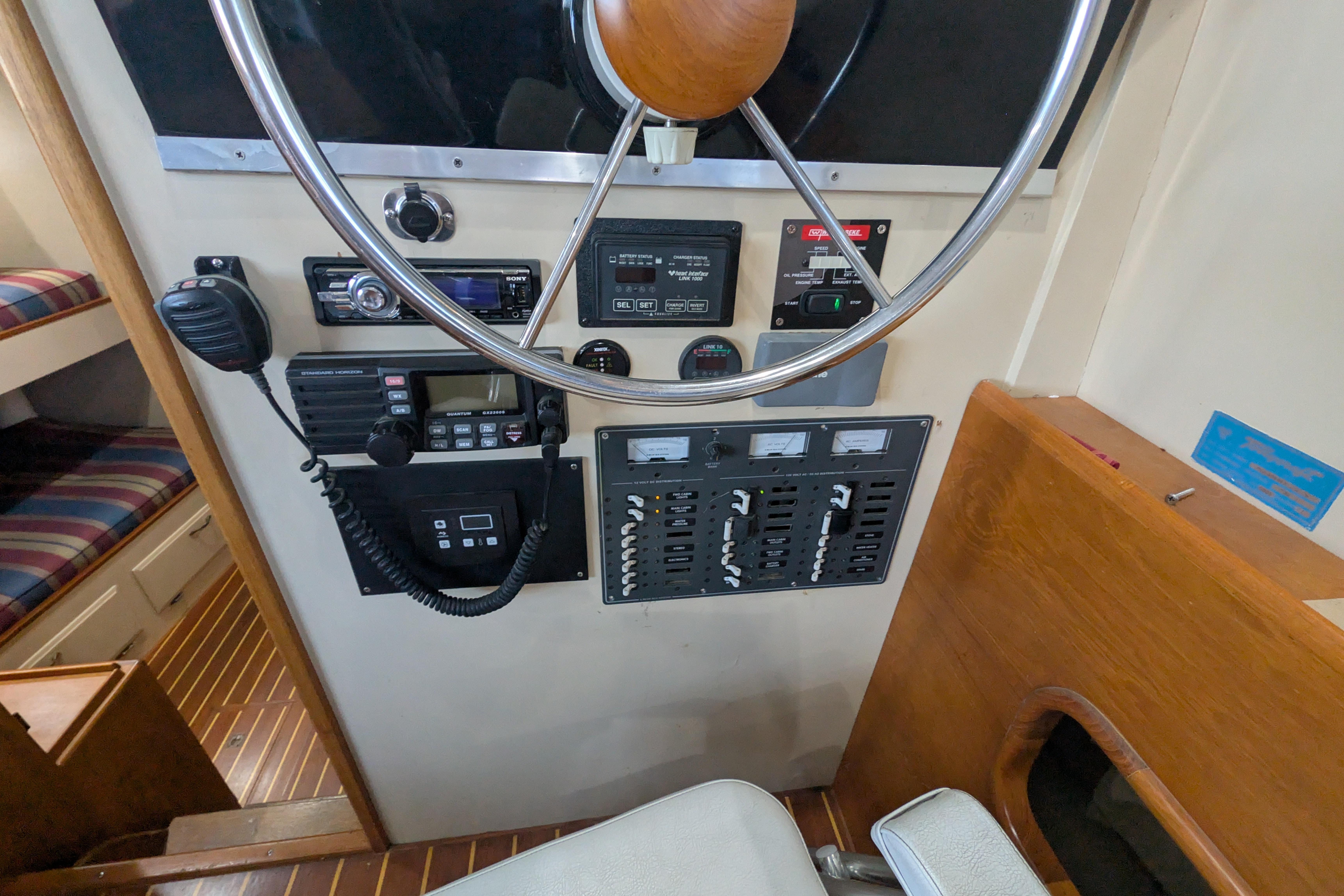 1975 Tollycraft 37 Sedan helm with steering wheel, control panels, and communication equipment.
