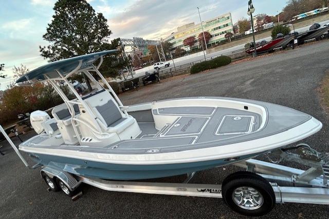 2025 Mako 24 APEX boat on trailer, parked outdoors, showcasing sleek design and modern features.