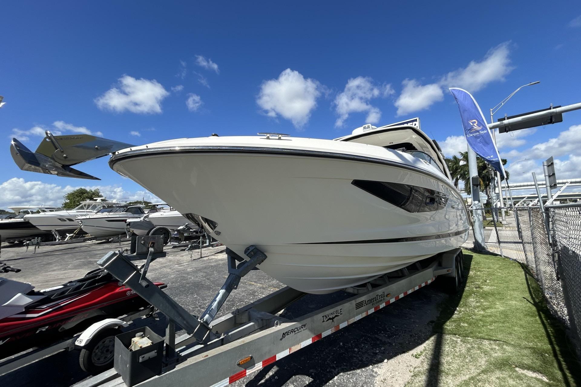 2019 Sea Ray SLX 350 Outboard boat on trailer under clear blue sky.