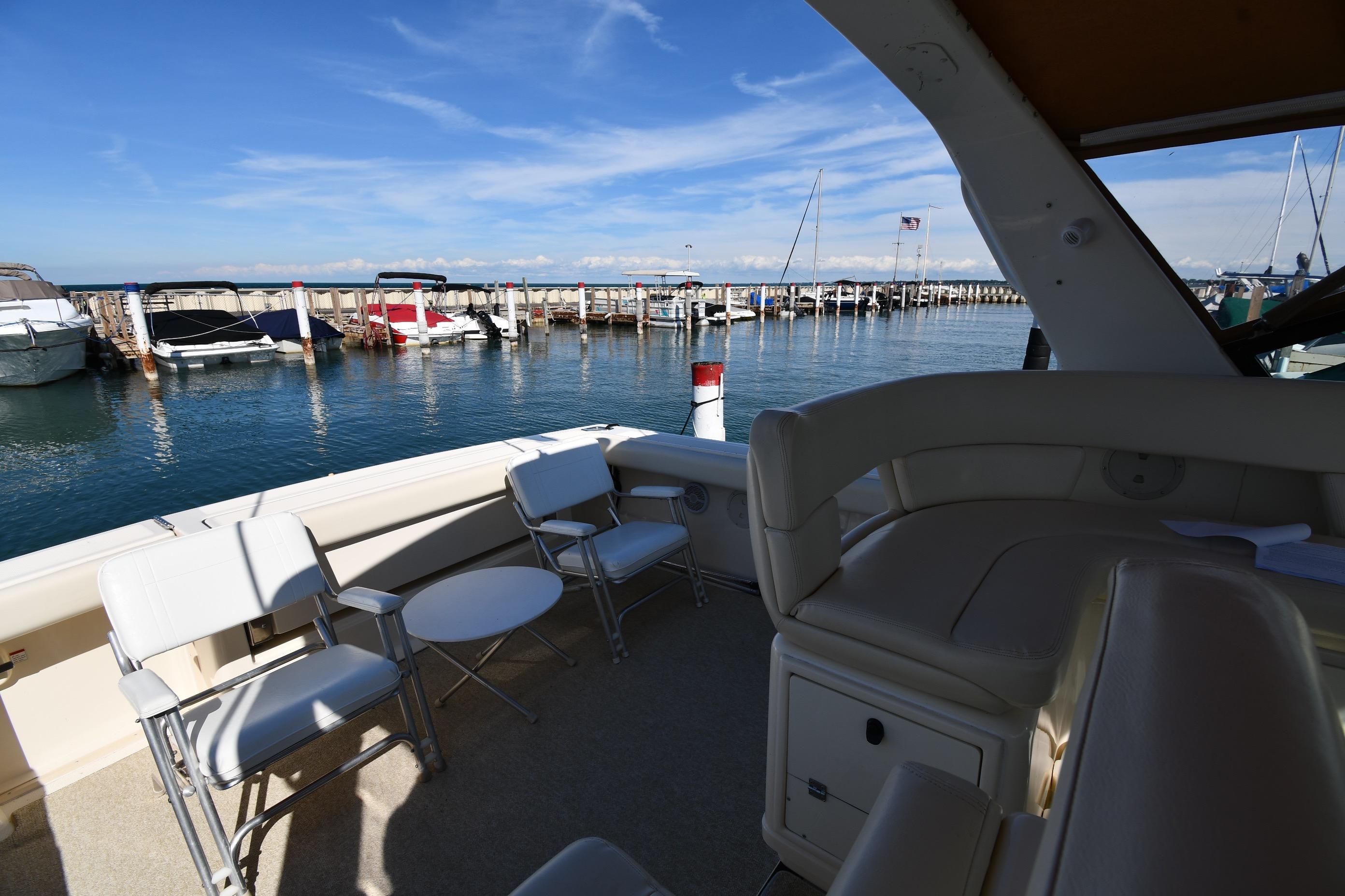1998 Tiara Yachts 3100 Open docked, featuring spacious seating and scenic marina view.