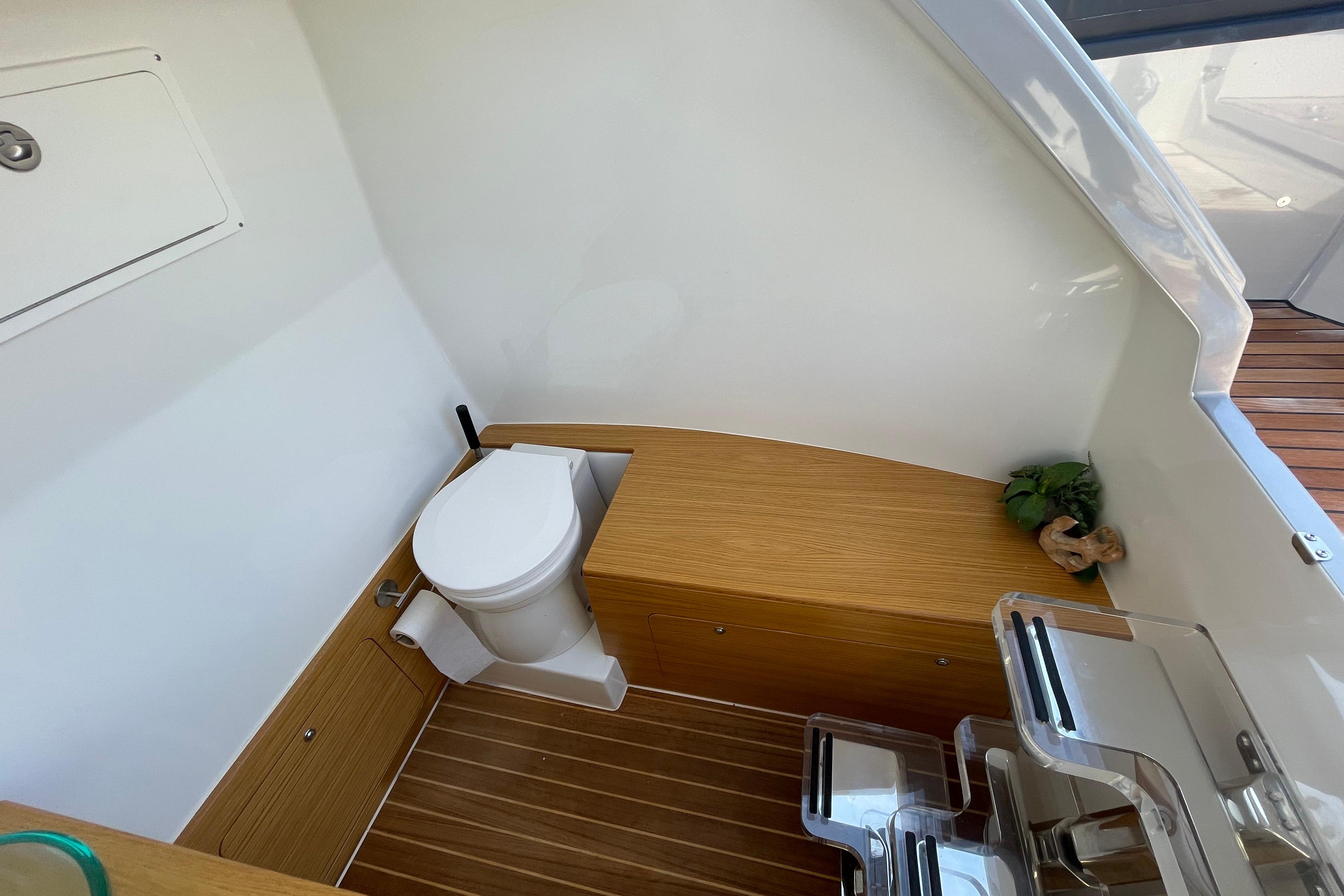 Modern boat bathroom with wooden accents, featuring a toilet and storage, Skipper-BSK BSK 38, 2023.
