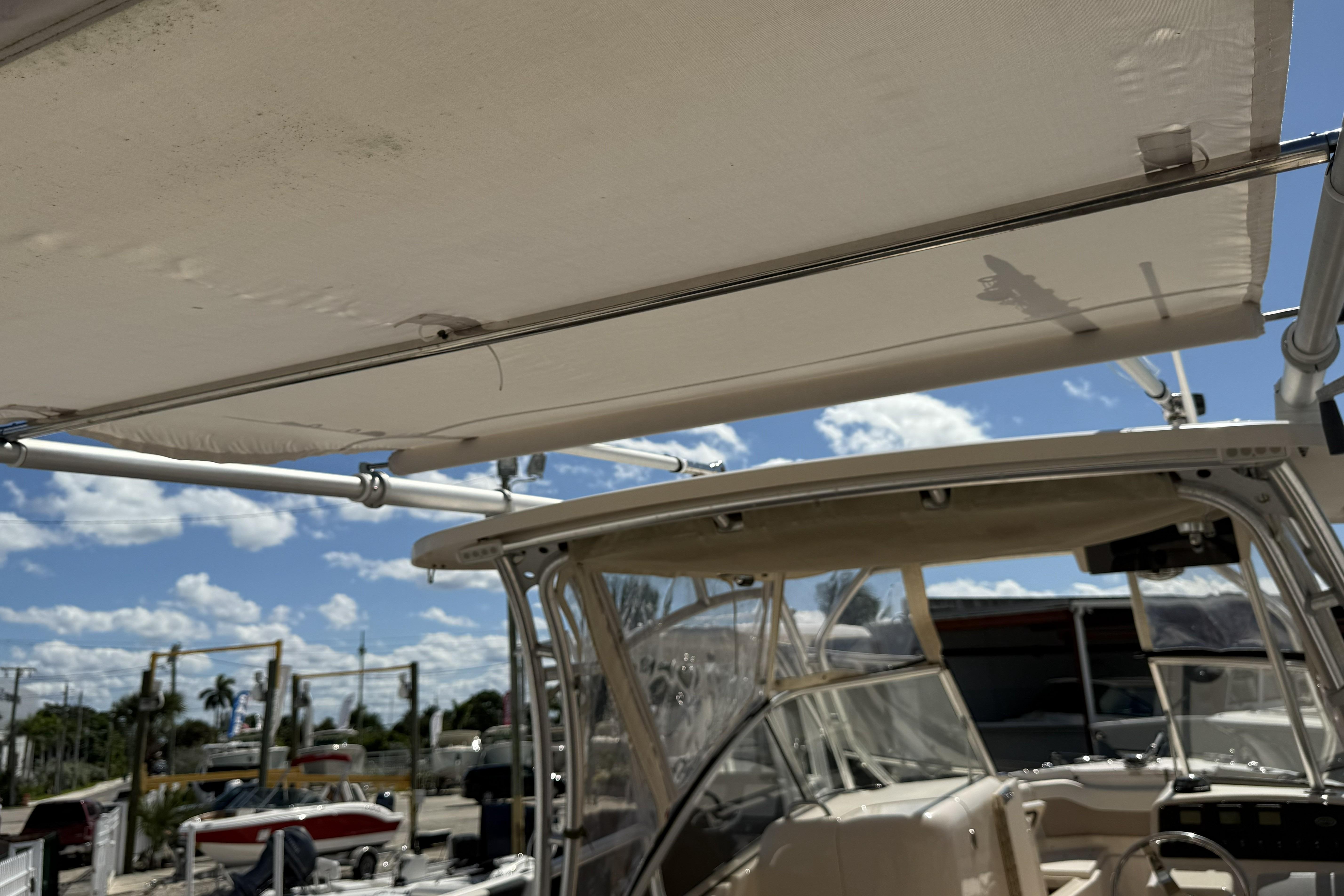 2014 Grady-White Freedom 275 boat with canopy, clear sky background.