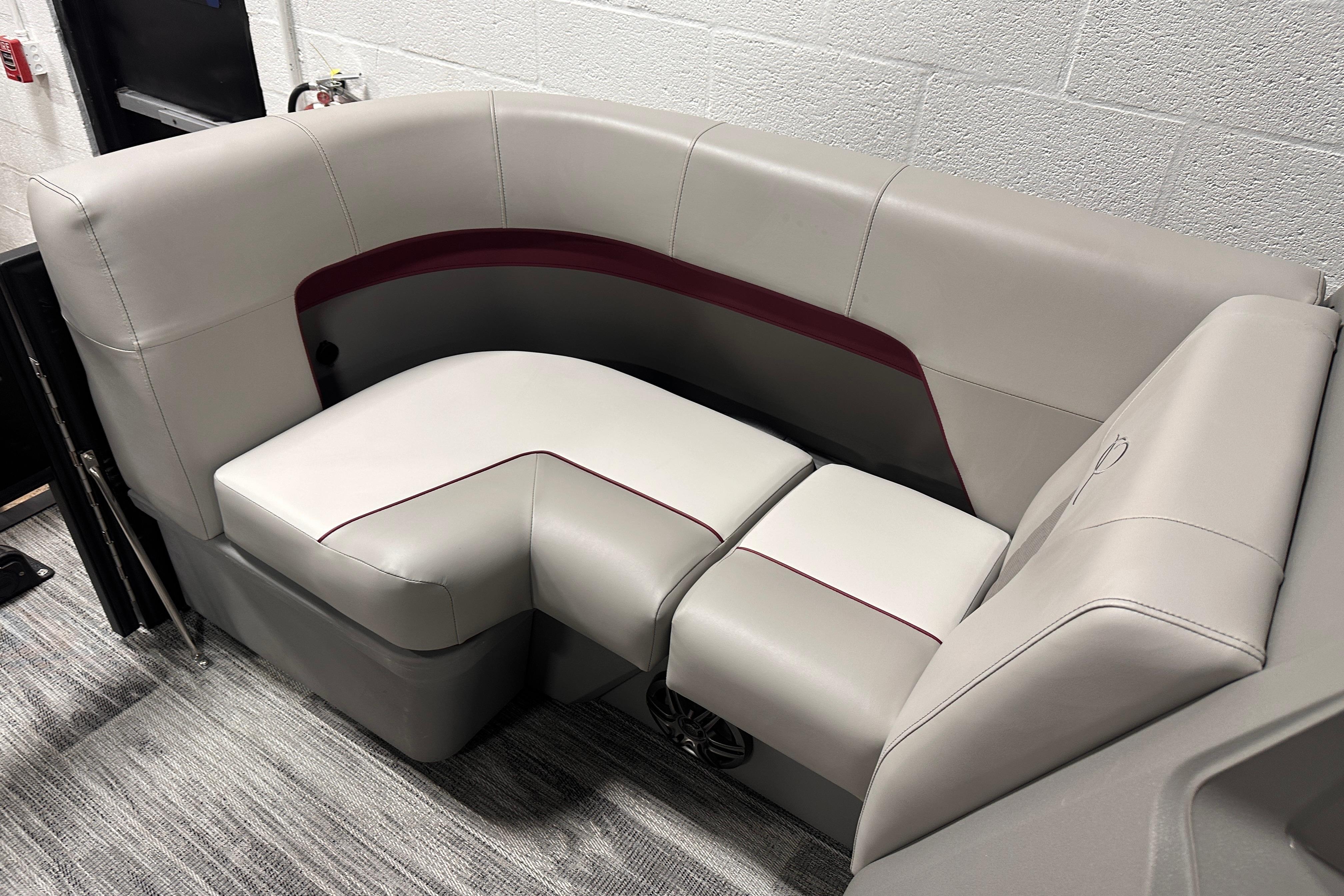 2025 Qwest 18 XRE Cruise boat interior with plush, beige seating and red accents.