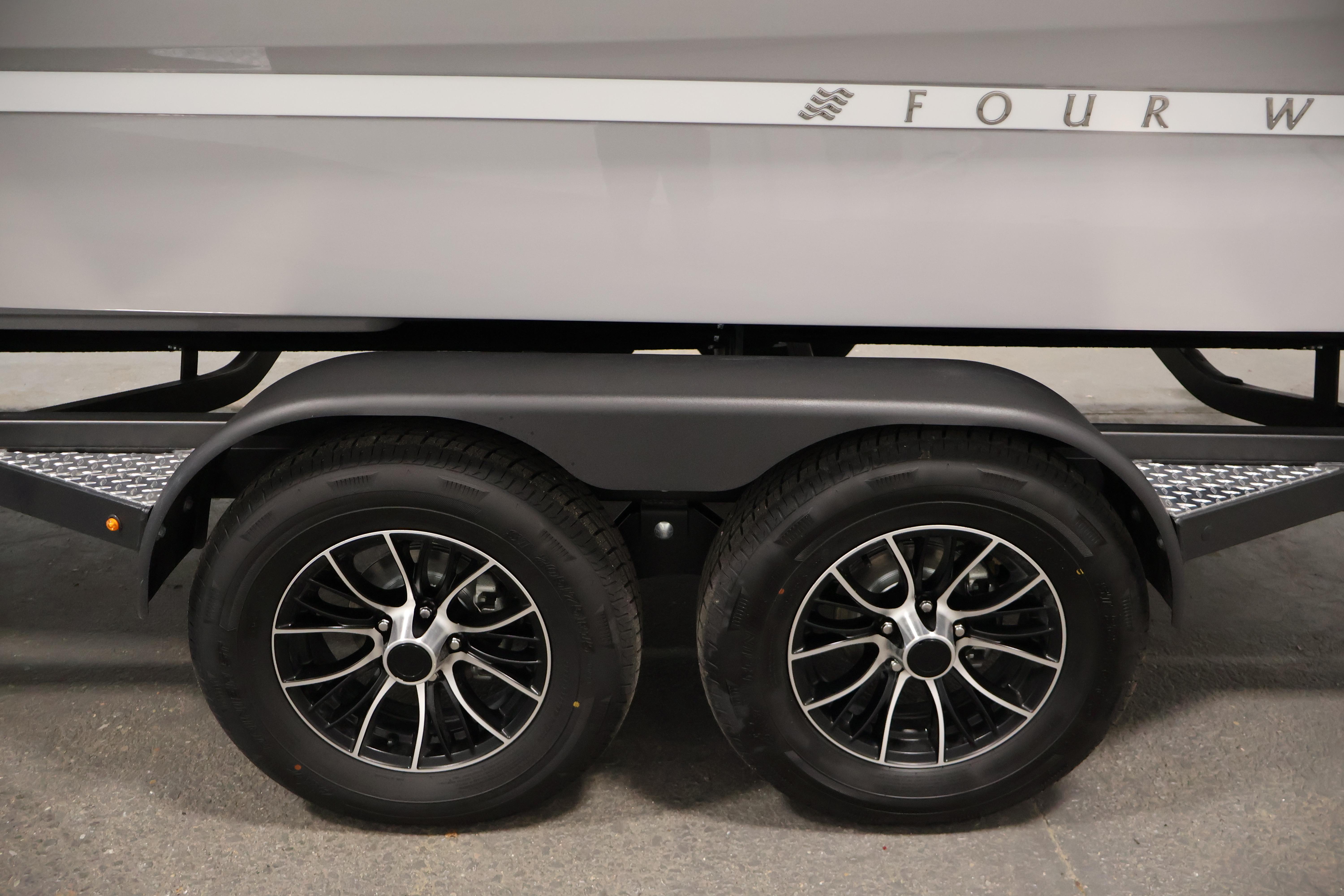 Trailer wheels of 2026 Four Winns H4 Freedom boat, featuring sleek black rims.