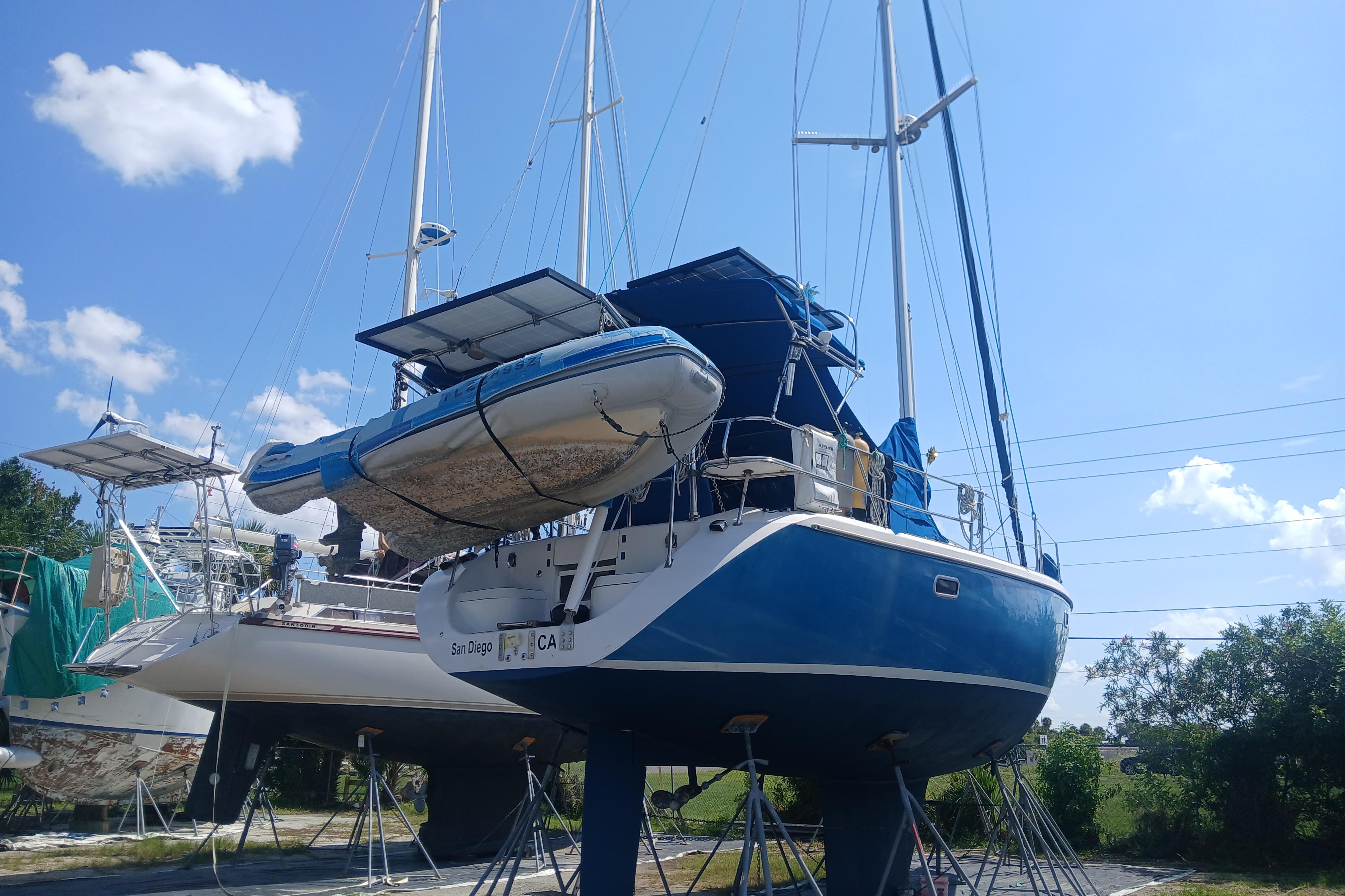 Catalina 42 MkII sailboat from 1995 on stands, with a dinghy attached, under a clear sky.