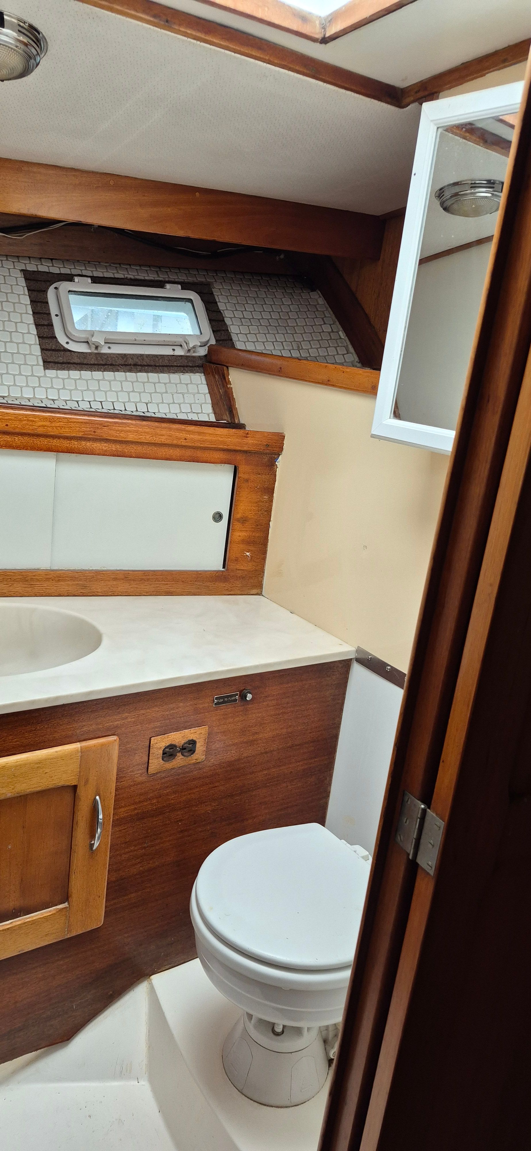 Interior of 1976 Egg Harbor 33 Sportfisher, bathroom with wood paneling.