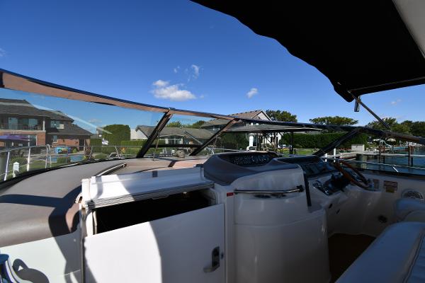 1997 Sea Ray 400 Sundancer cockpit with clear sky and waterfront view.