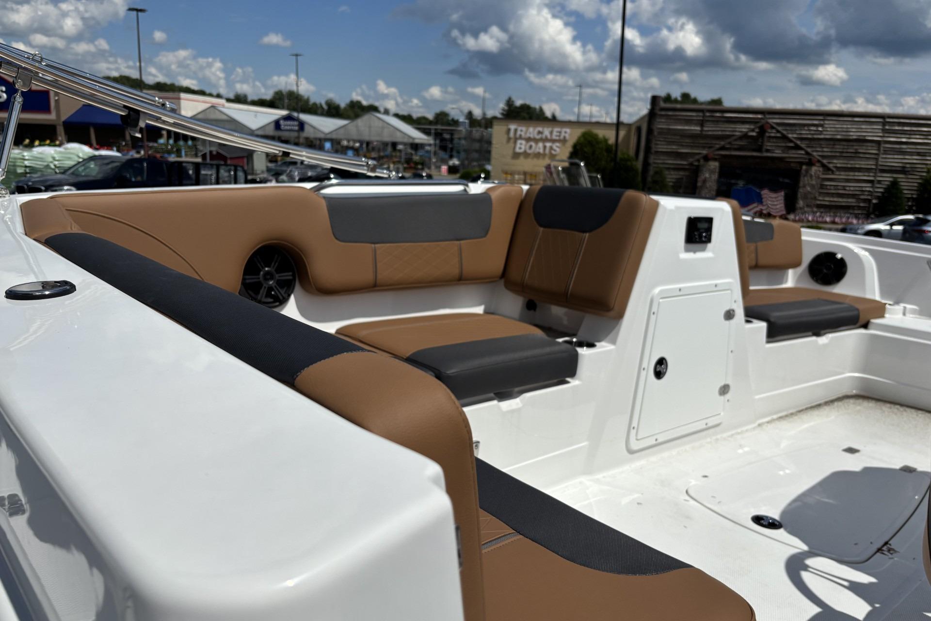 Interior of 2026 Tahoe 1950 boat with tan and black seating under a cloudy sky.
