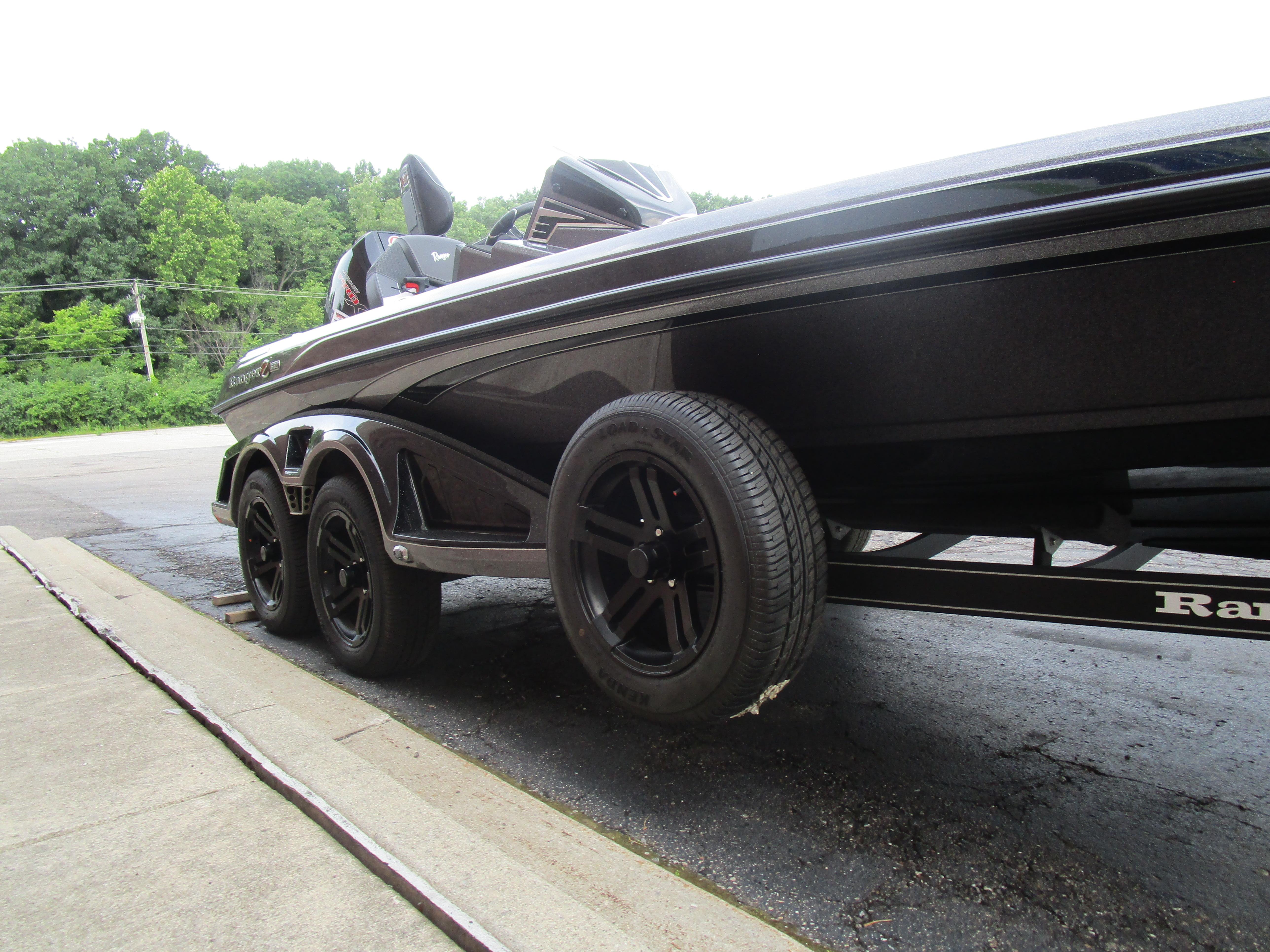 2025 Ranger Z520 boat on trailer with black wheels, parked outdoors.