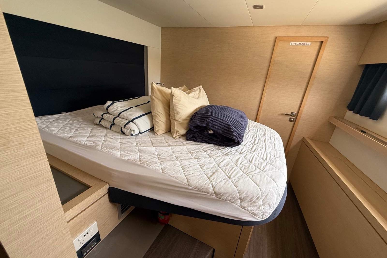 Cozy cabin interior of 2019 Fountaine Pajot Soana 47 catamaran with neatly arranged bedding.