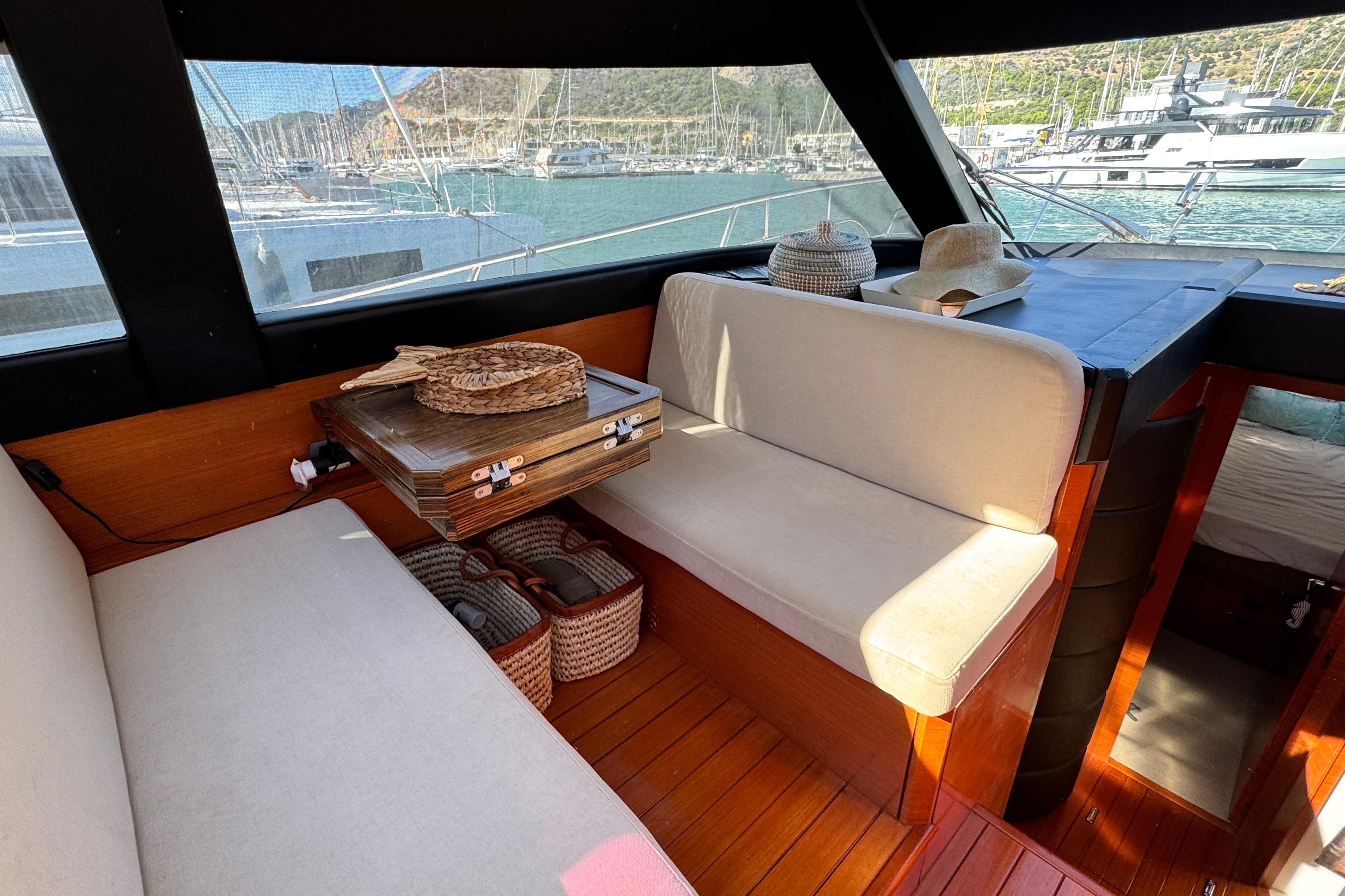 Interior of 2007 Doma 5 boat with seating, table, and scenic marina view.