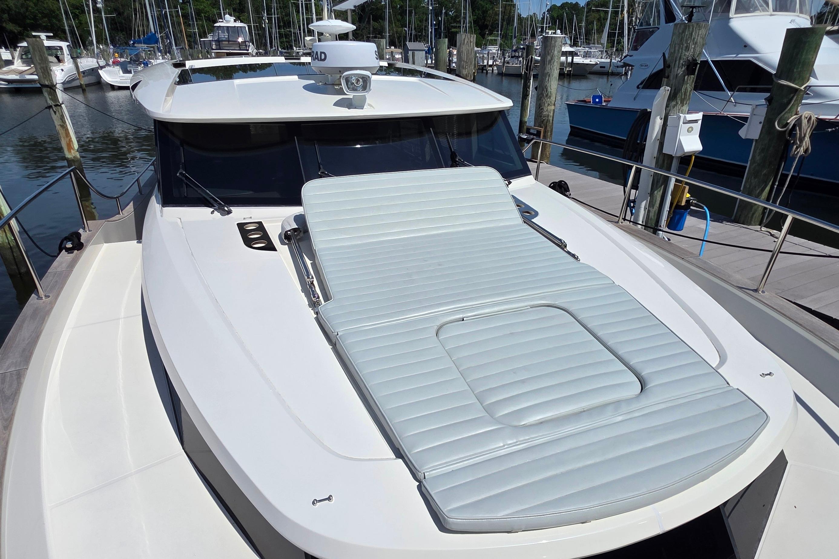 2023 Greenline 40 yacht with sunbed on deck, docked at marina.