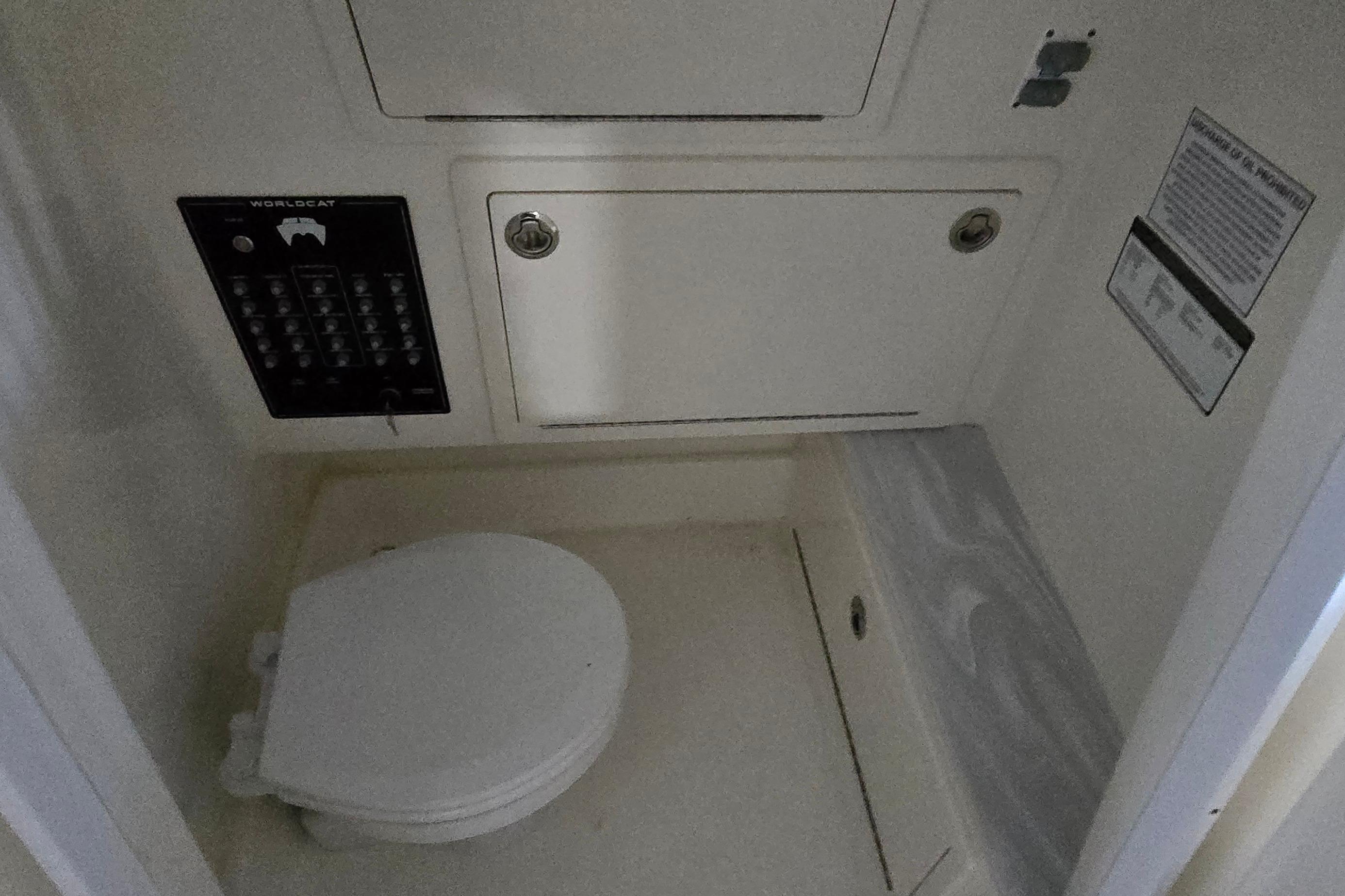 2024 WorldCat 280 CC-X boat interior with toilet and control panel.