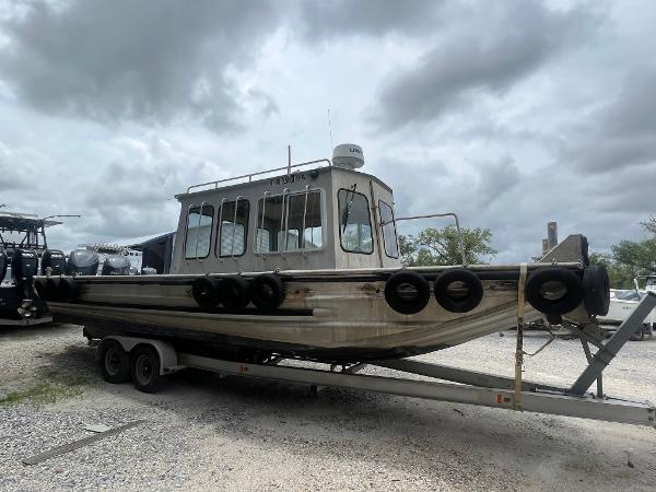 Custom Flat 28 Cabin Boat 2010 on trailer under cloudy sky.