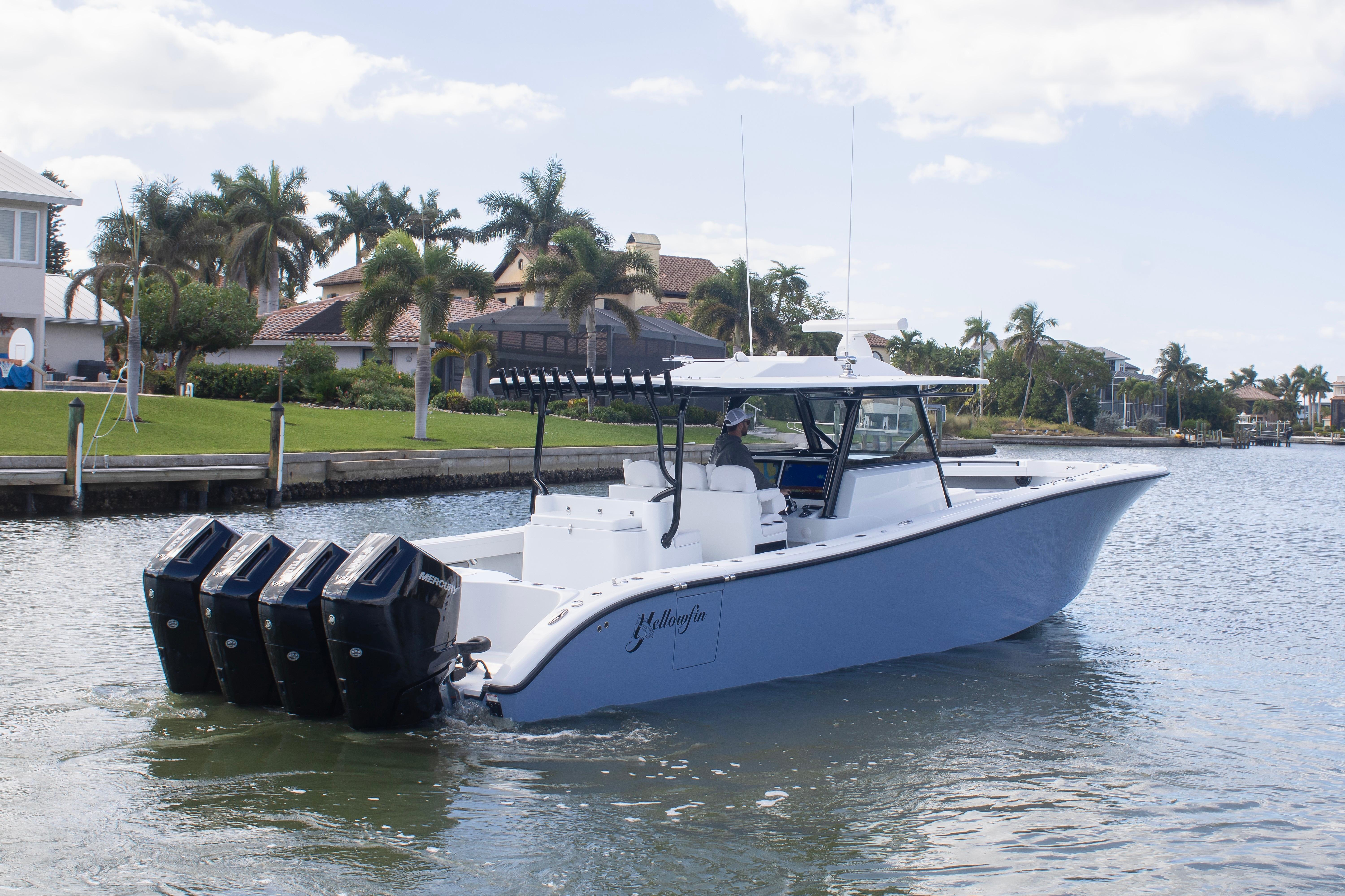 2026 Yellowfin 42 Offshore boat cruising on a scenic waterway with palm trees.