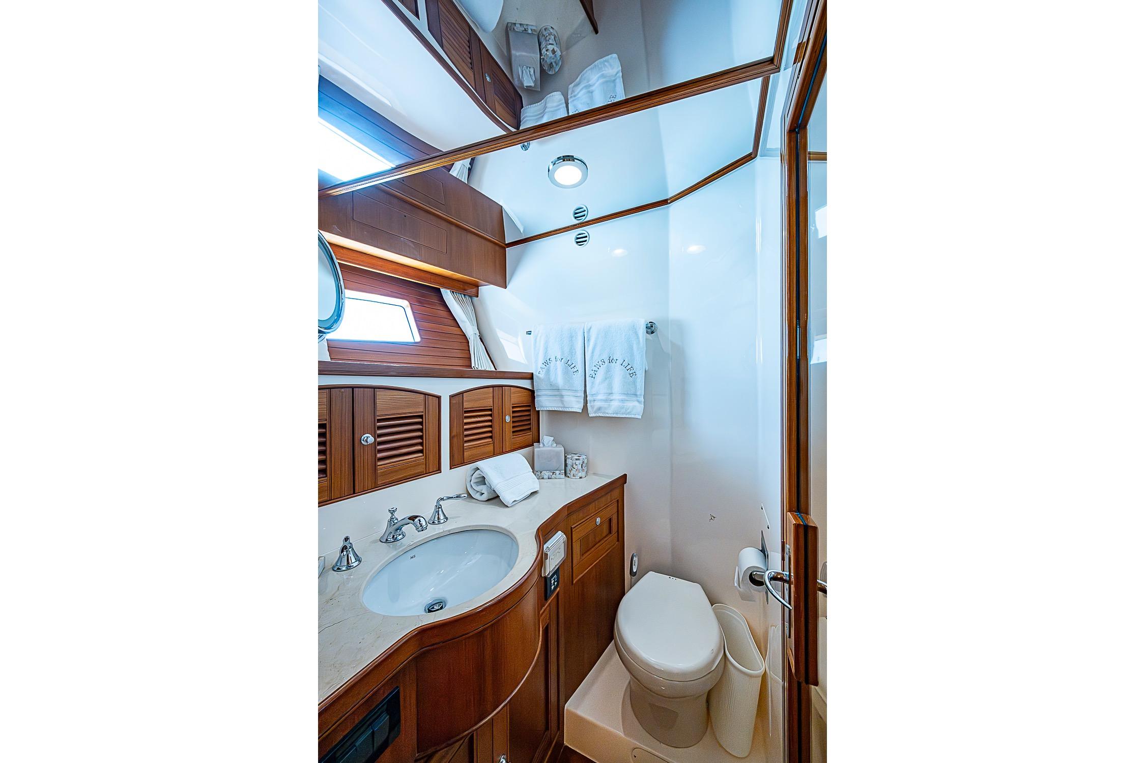 Luxurious bathroom in 2014 Marlow 80 Explorer yacht with wood accents and modern fixtures.