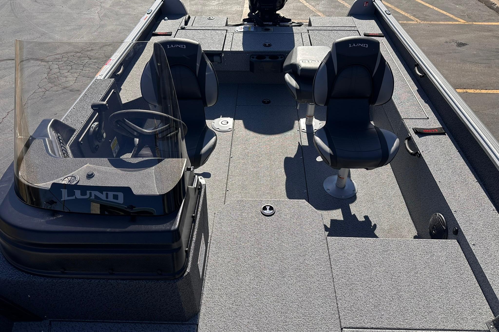 2026 Lund 1875 Impact XS SS boat interior with seating and steering console.