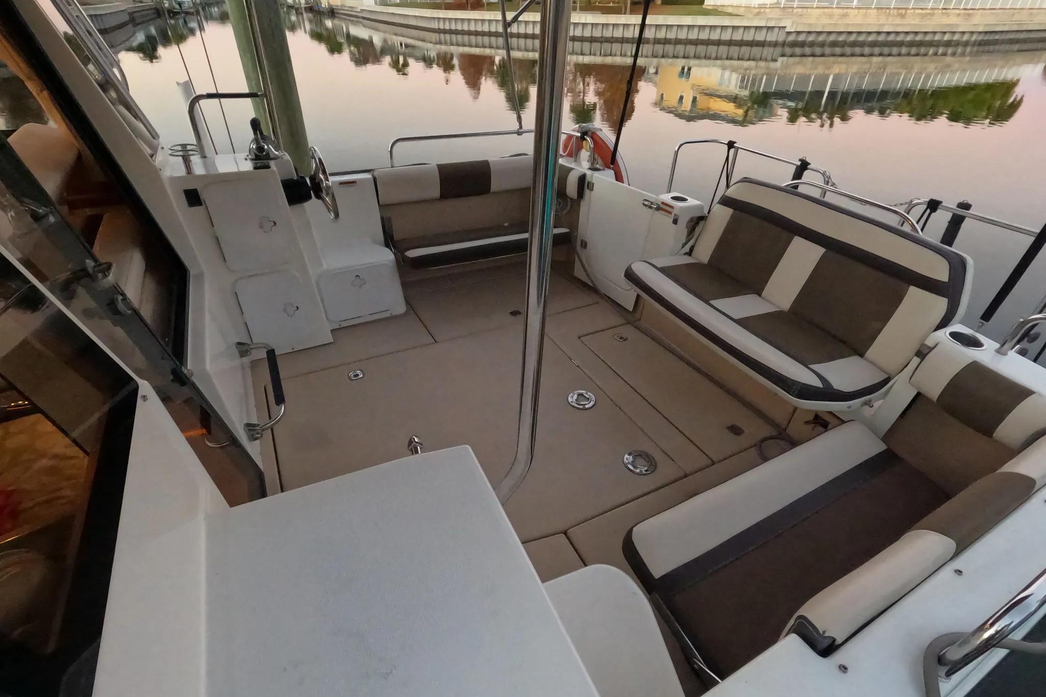 2015 Ranger Tugs R-29 S boat interior with cushioned seating and water view.