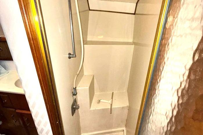 Shower area in 1983 Egg Harbor 40 Sedan yacht with wooden accents and compact design.