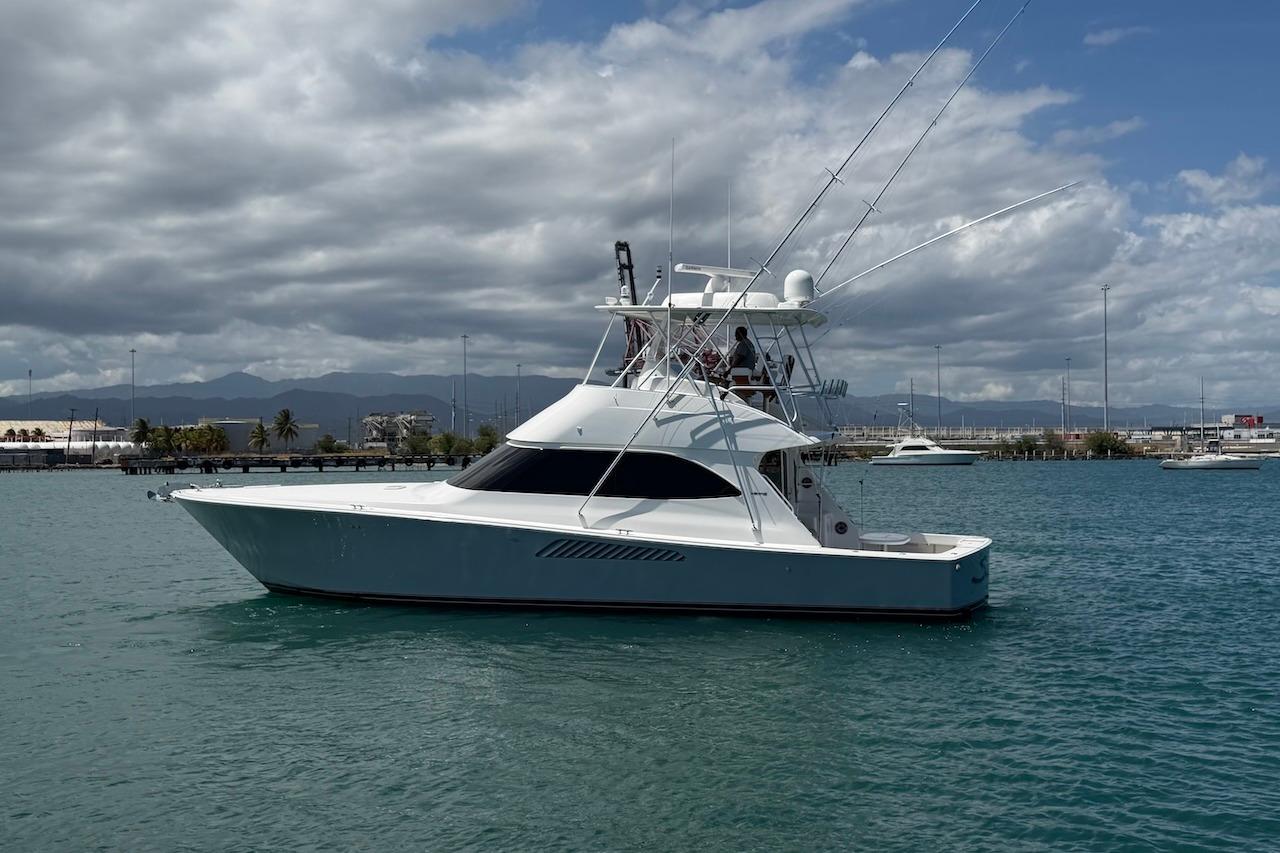 2012 Viking 50 Convertible yacht on calm water under cloudy sky.