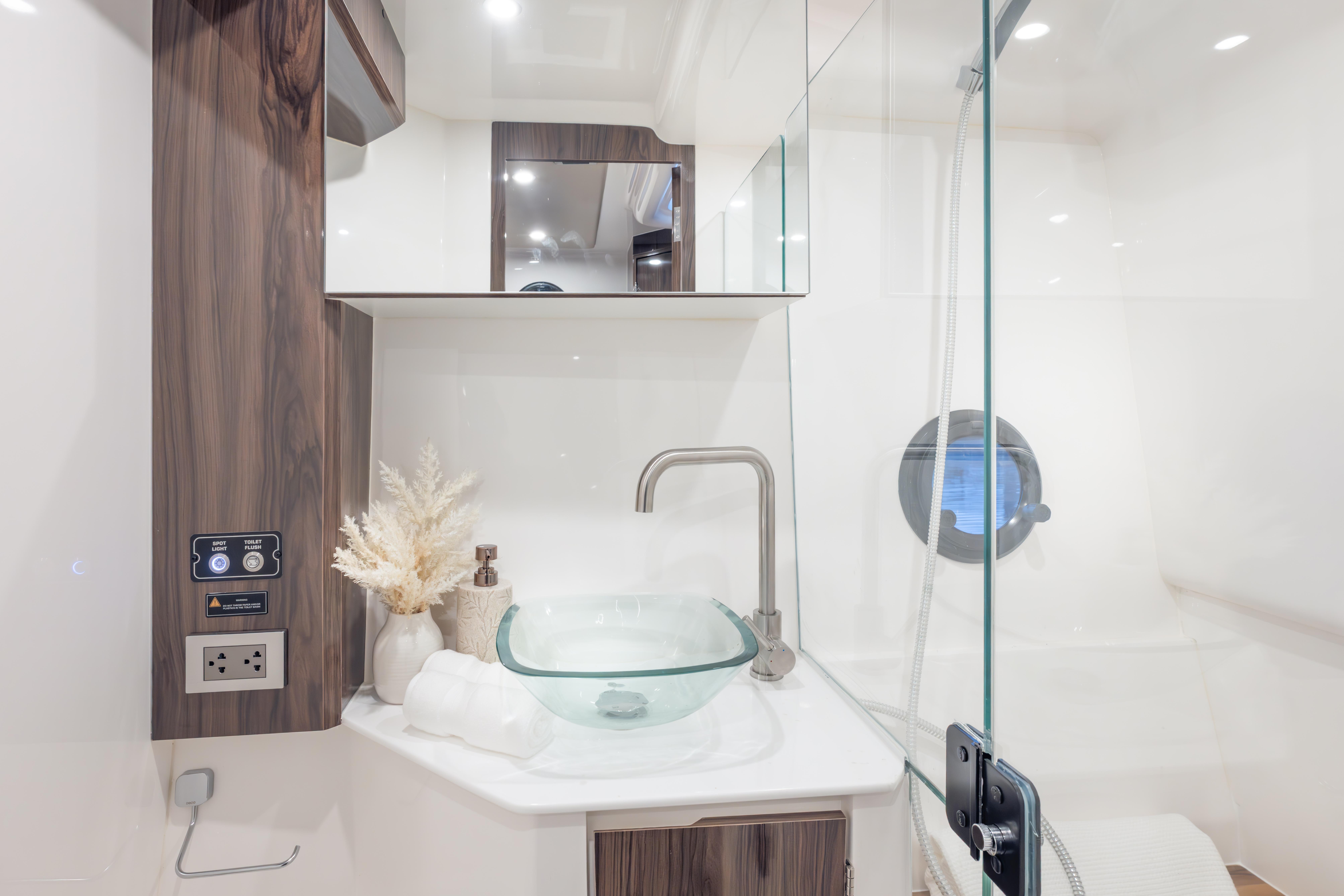 Modern bathroom in 2026 Hanover 387 yacht with glass sink and elegant decor.