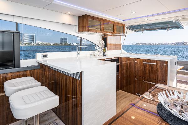 Luxurious interior of 2021 Riviera 5400 Sport Yacht with modern kitchen and ocean view.