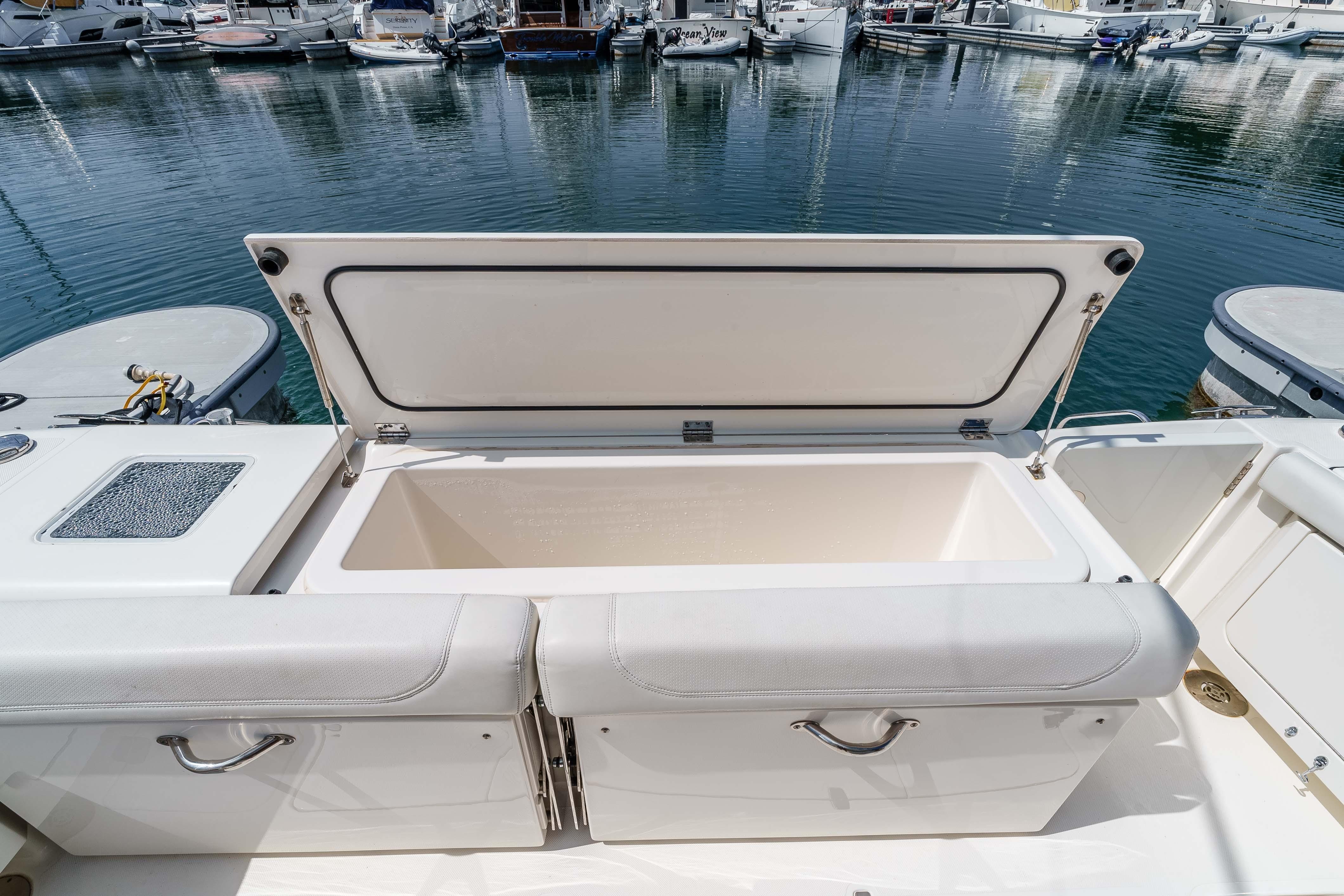 2022 Pursuit OS 385 Offshore boat with open storage compartment at marina.
