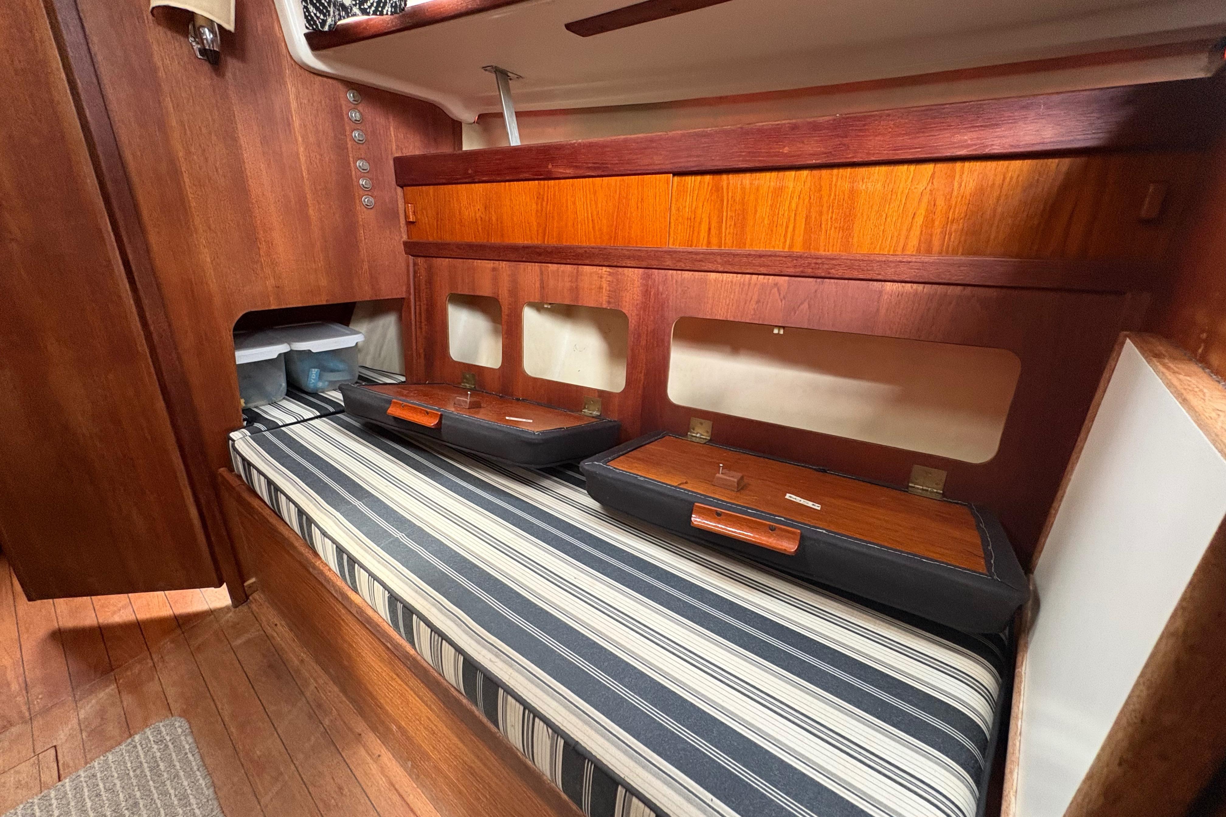 1981 Sabre 31 interior with striped cushions and wooden cabinetry.