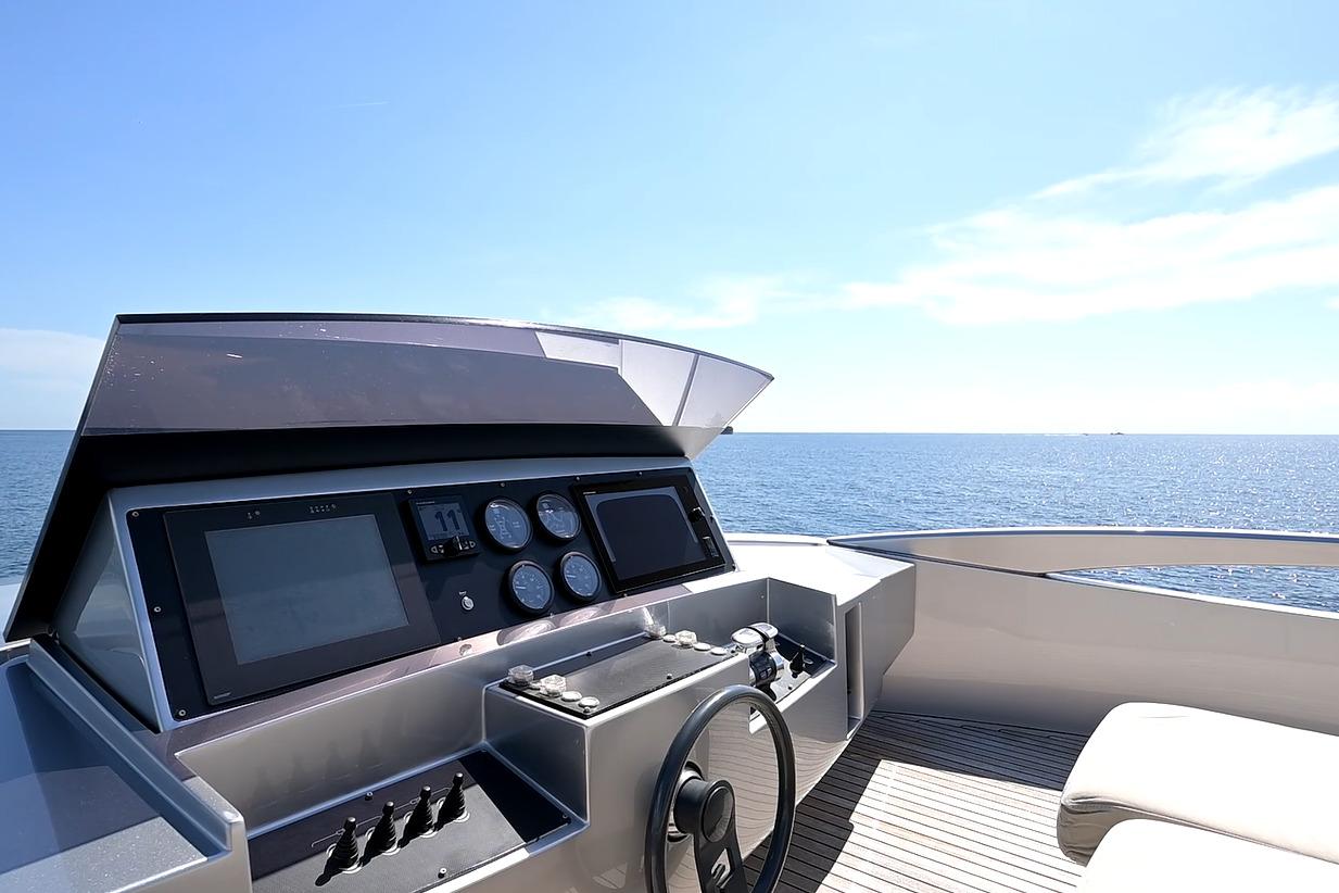 Helm of 2015 Pershing 92 yacht with ocean view under clear blue sky.